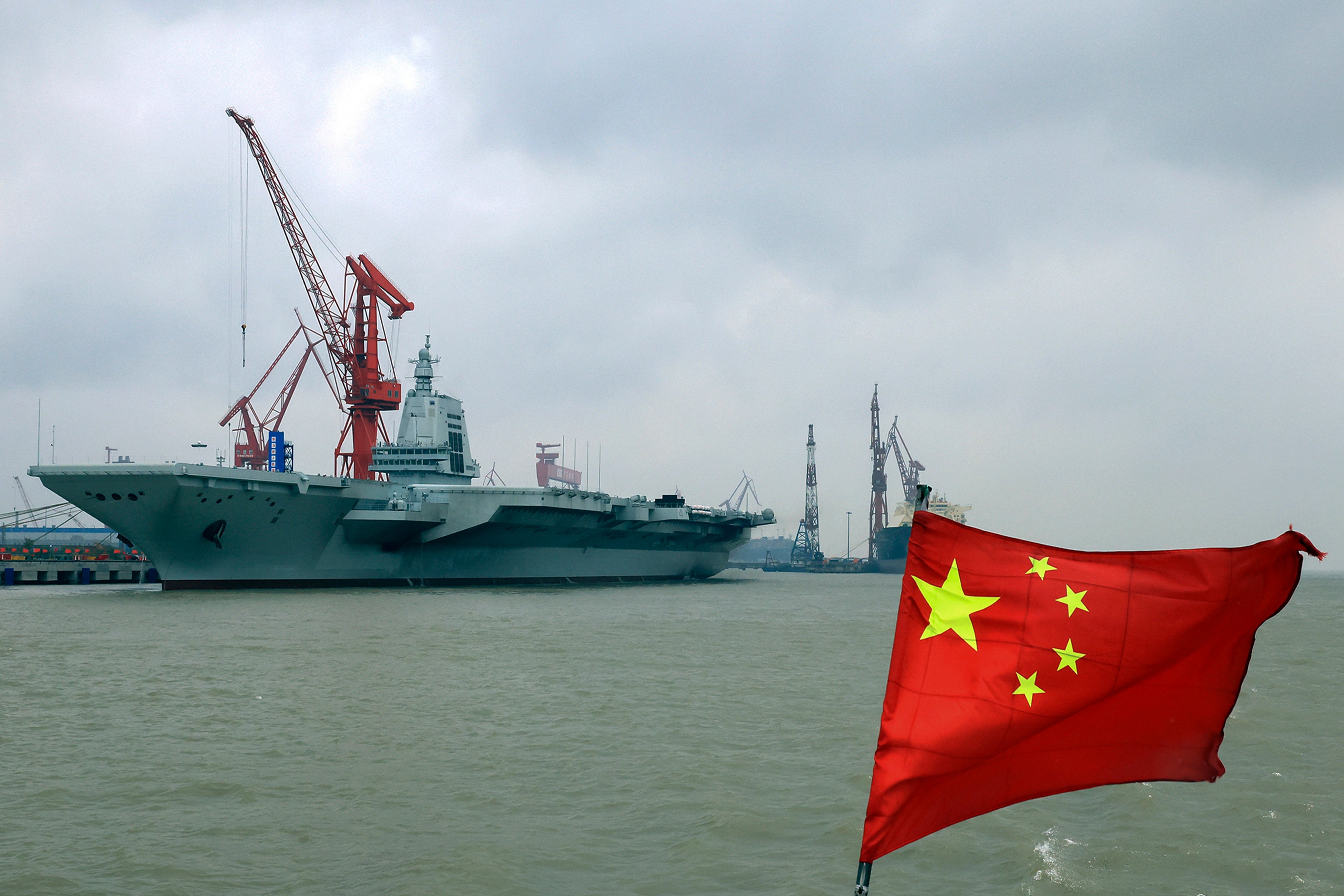 A Chinese flag flutters in the wind near China’s third aircraft carrier, the Fujian, as it prepares to set out from Shanghai. Photo: AP