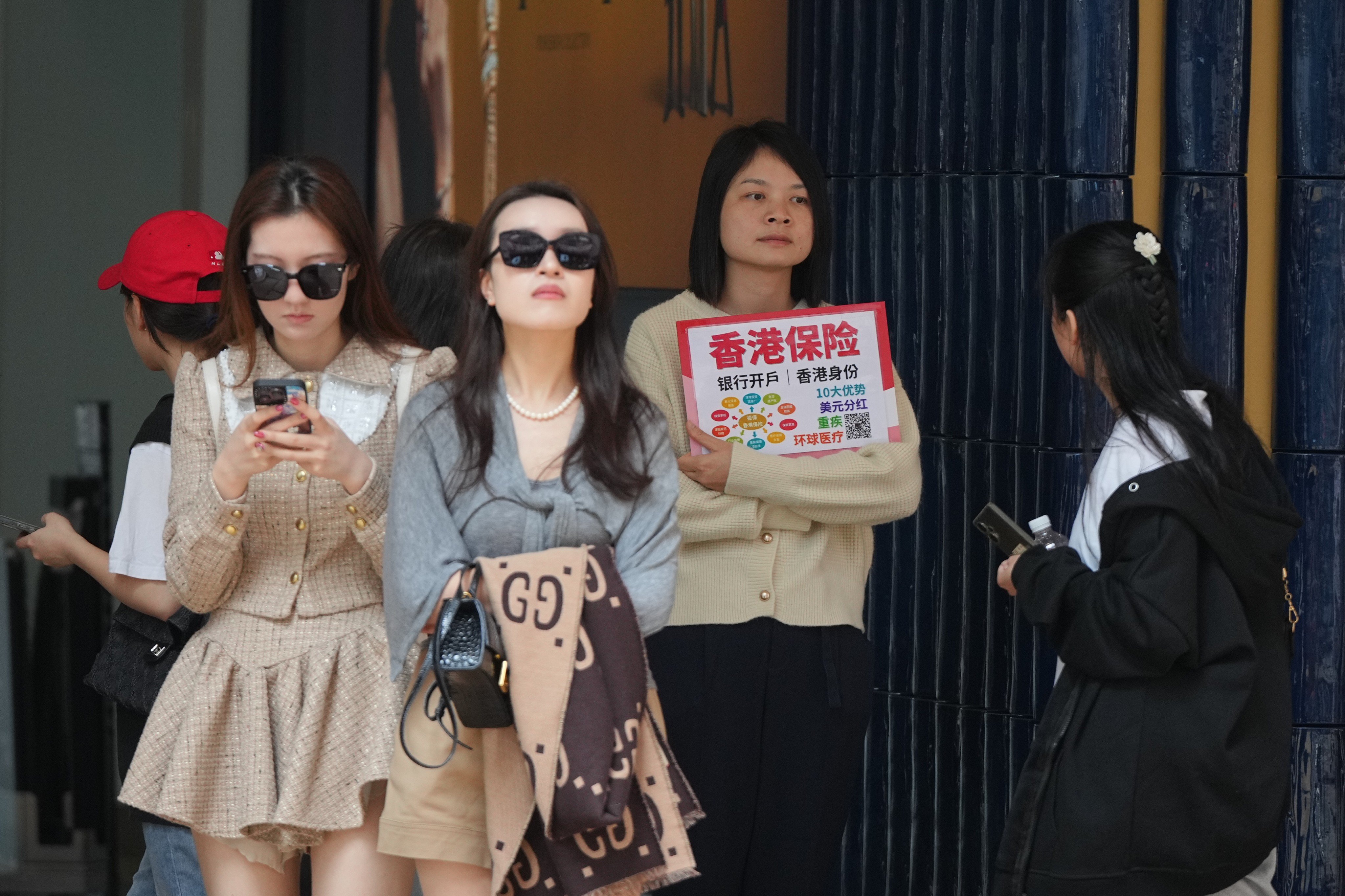 Insurance sales agents approach mainland tourists in Tsim Sha Tsui on February 20, 2024. Photo: Eugene Lee