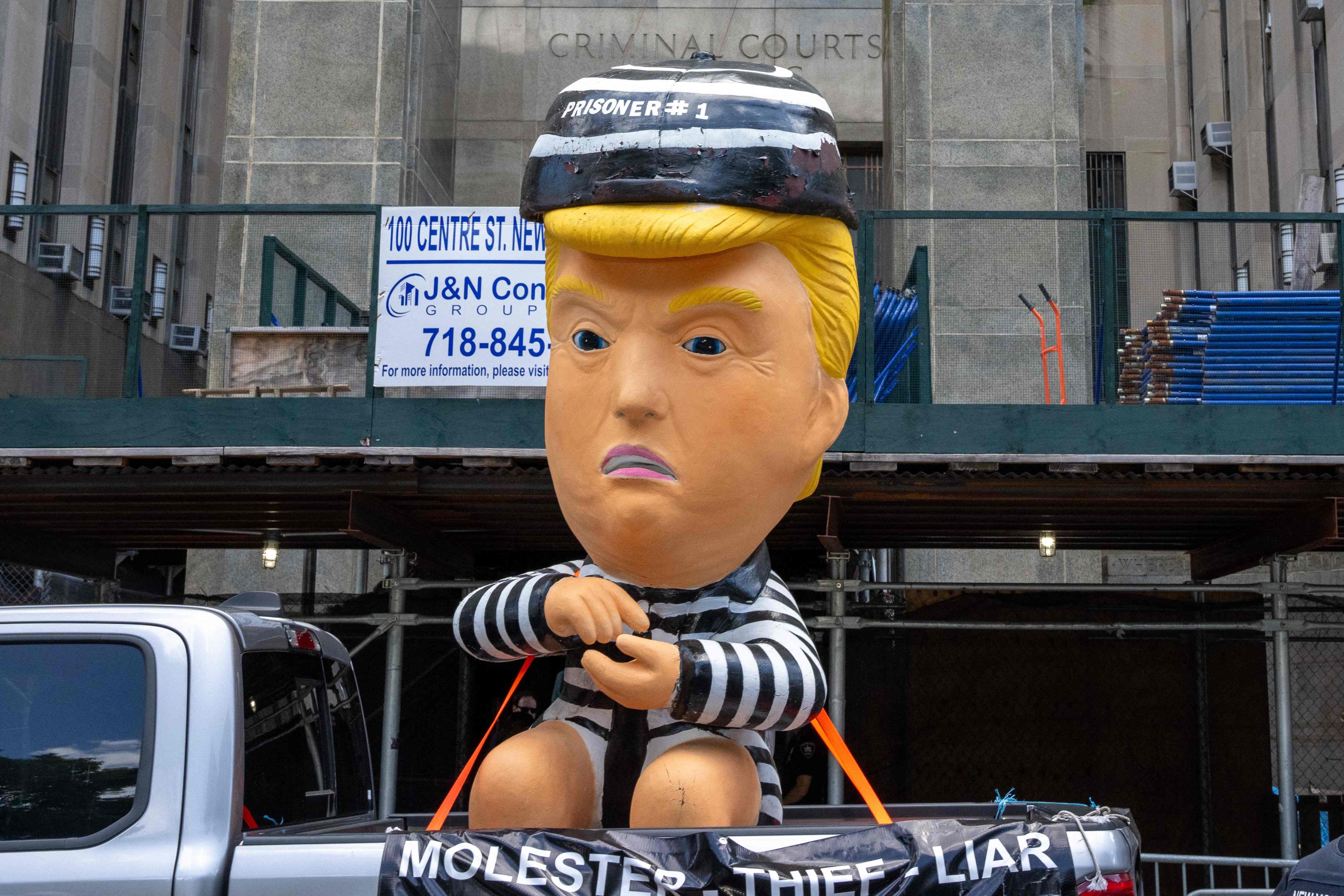 A truck drives by the courthouse with a balloon depicting former US president Donald Trump in a prison garb in New York on Tuesday. Photo: AFP