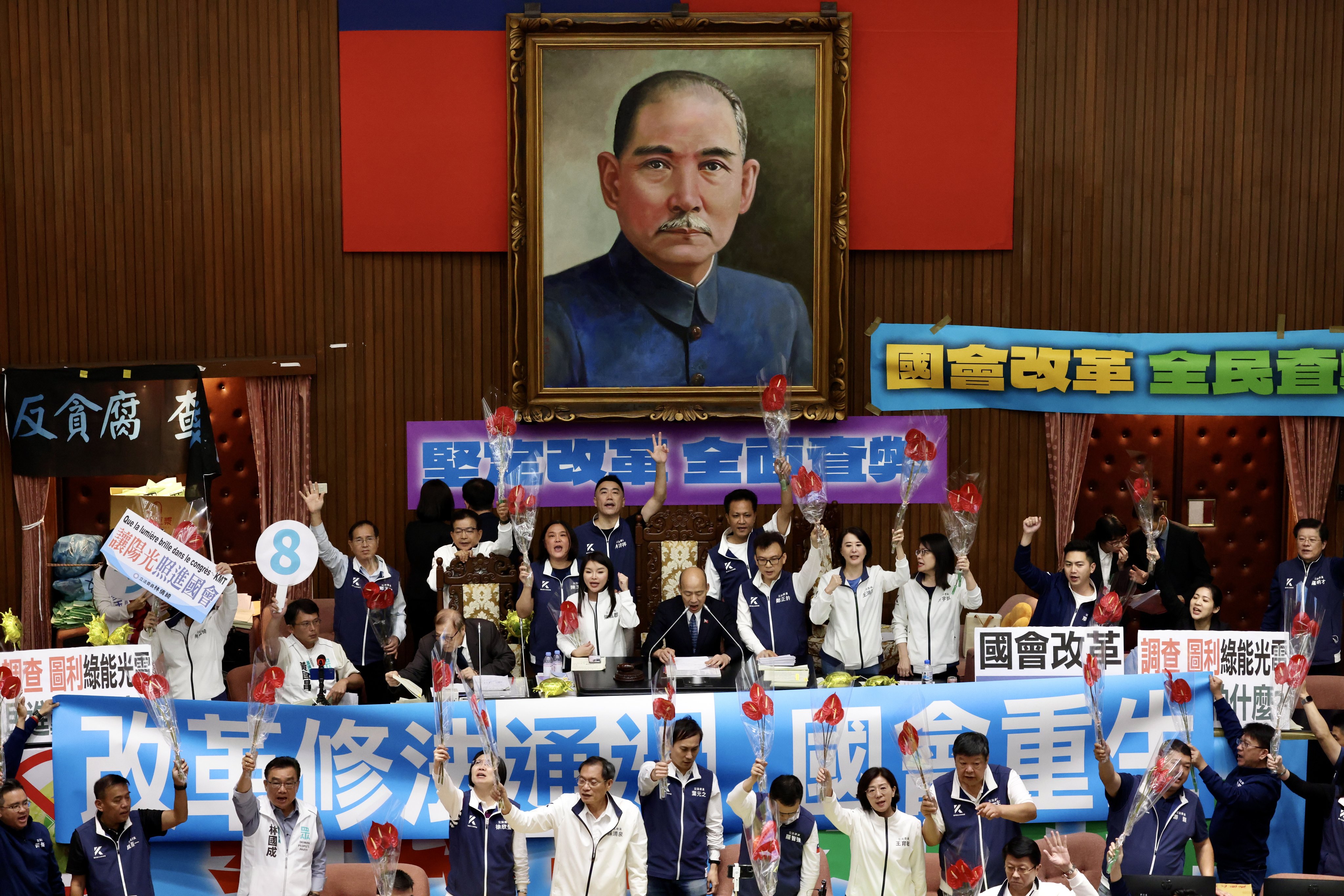 Opposition lawmakers in Taiwan celebrate inside the legislature after passing controversial bills to oversee the power of the executive branch on Tuesday. Photo: EPA