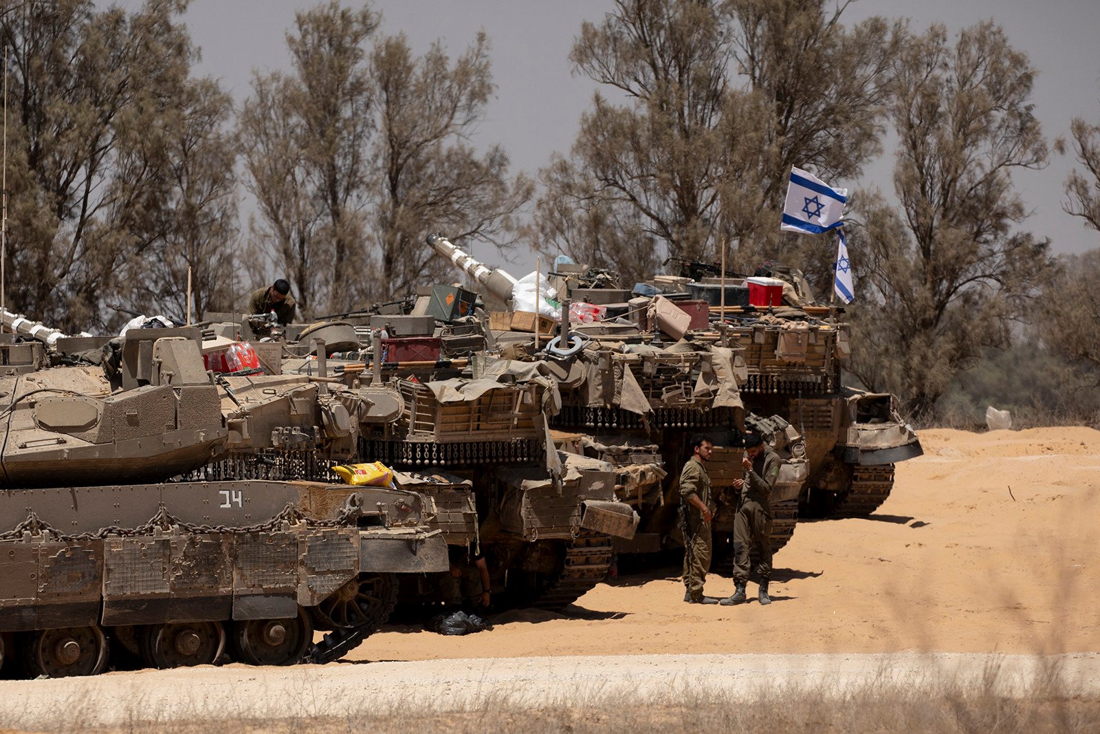 Israeli soldiers stand near tanks a long the border with the Gaza Strip. Photo: TNS