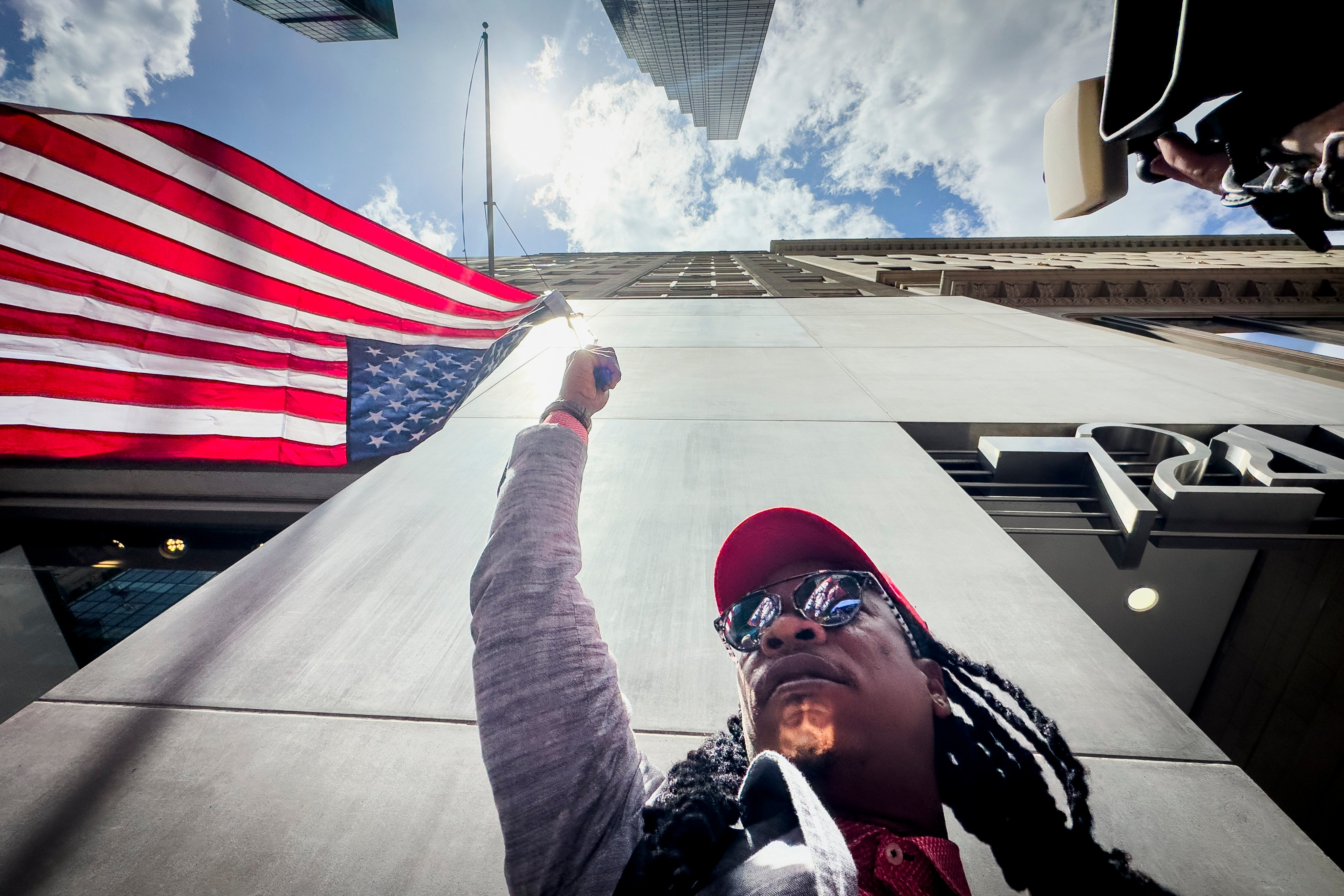A supporter of former president Donald Trump waves an inverted American flag during a demonstration outside Trump Tower in New York on May 31. Photo: AP