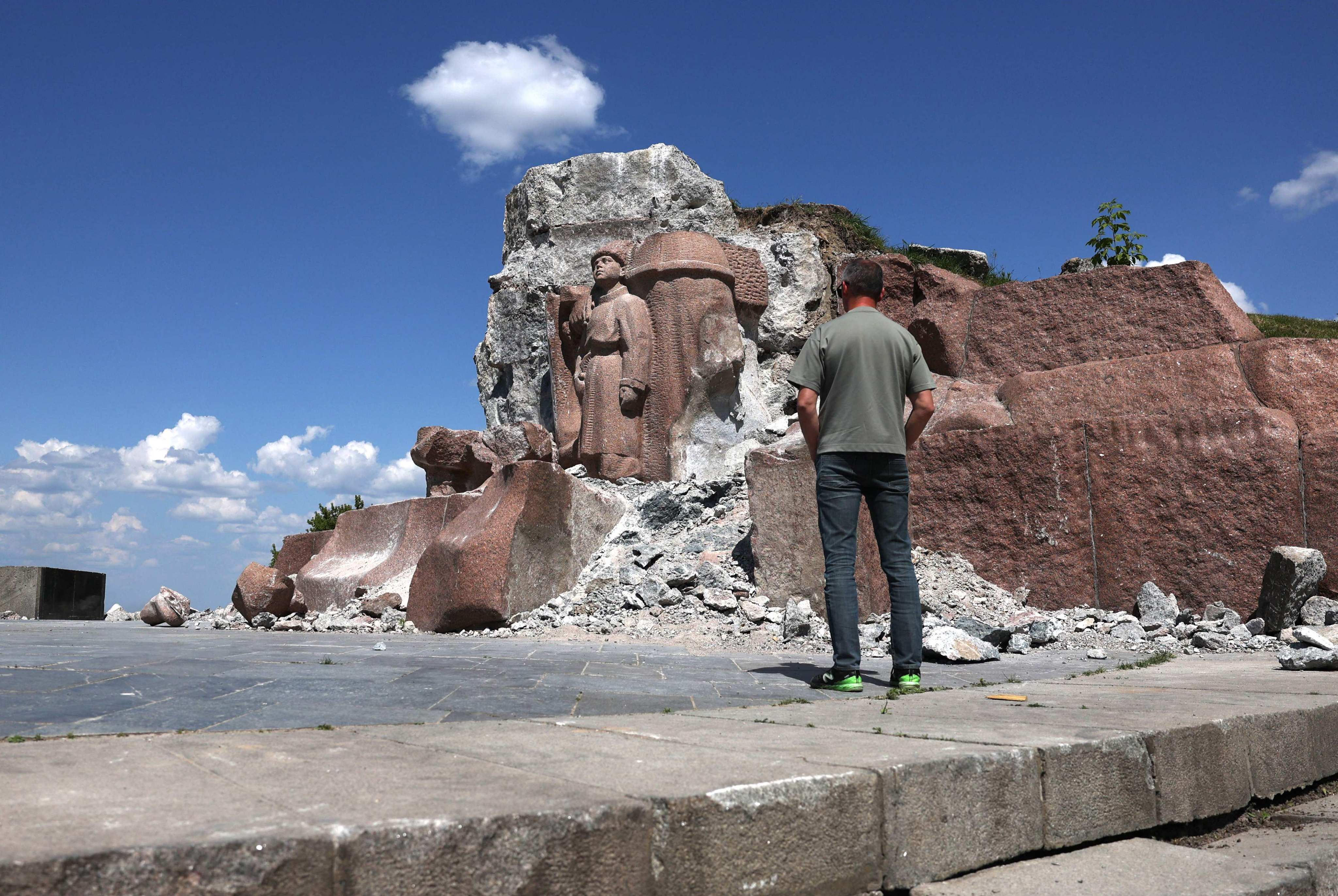A man stands in front of a fragment of a dismantled monument dedicated to the friendship of the Ukrainian and Russian peoples in a park in the center of Kyiv, on May 20, 2024, amid the Russian invasion in Ukraine. Photo: AFP