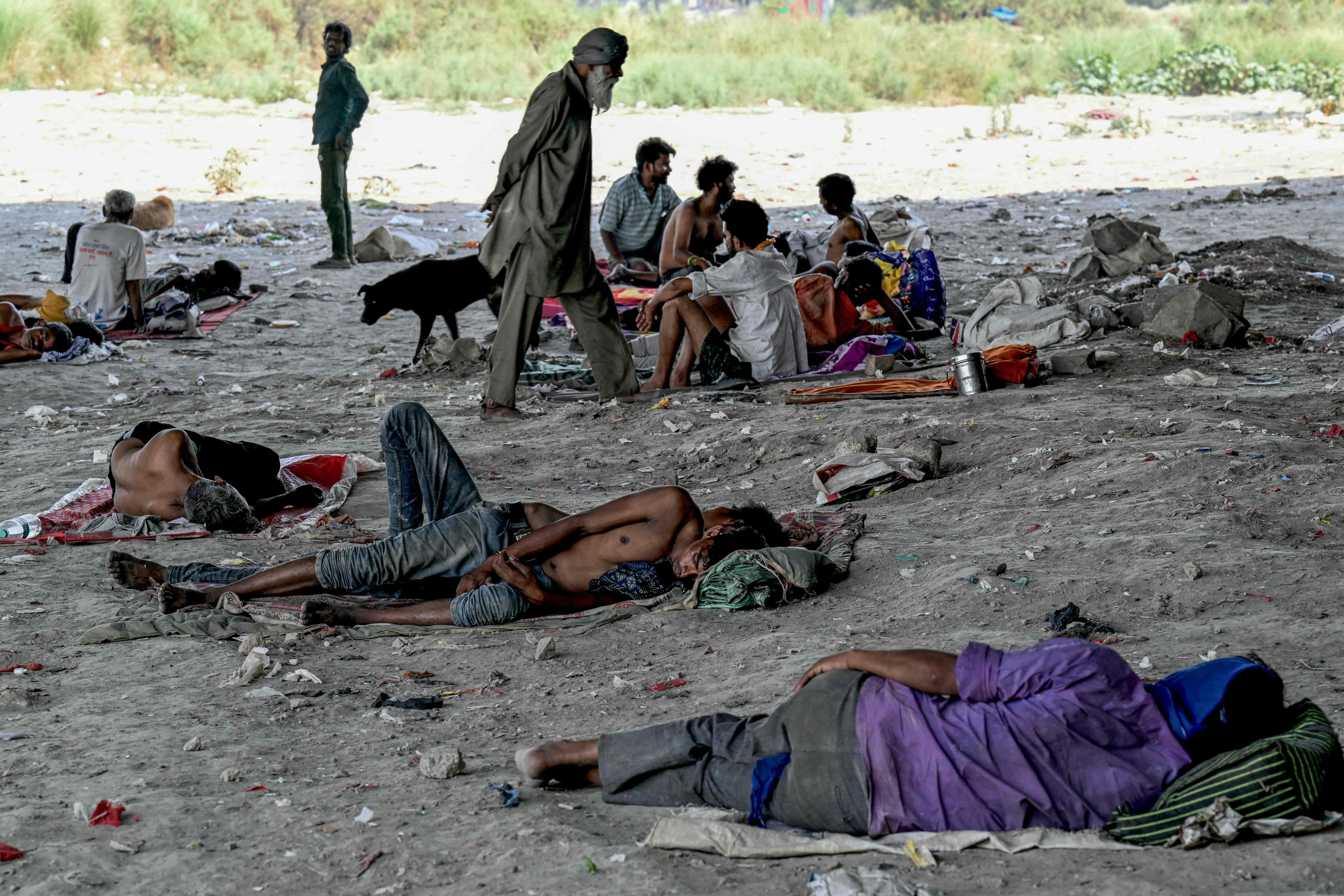 Homeless people are seen resting under a flyover on the banks of the Yamuna river in  New Delhi to shield themselves from the sun on May 31. Photo: AFP