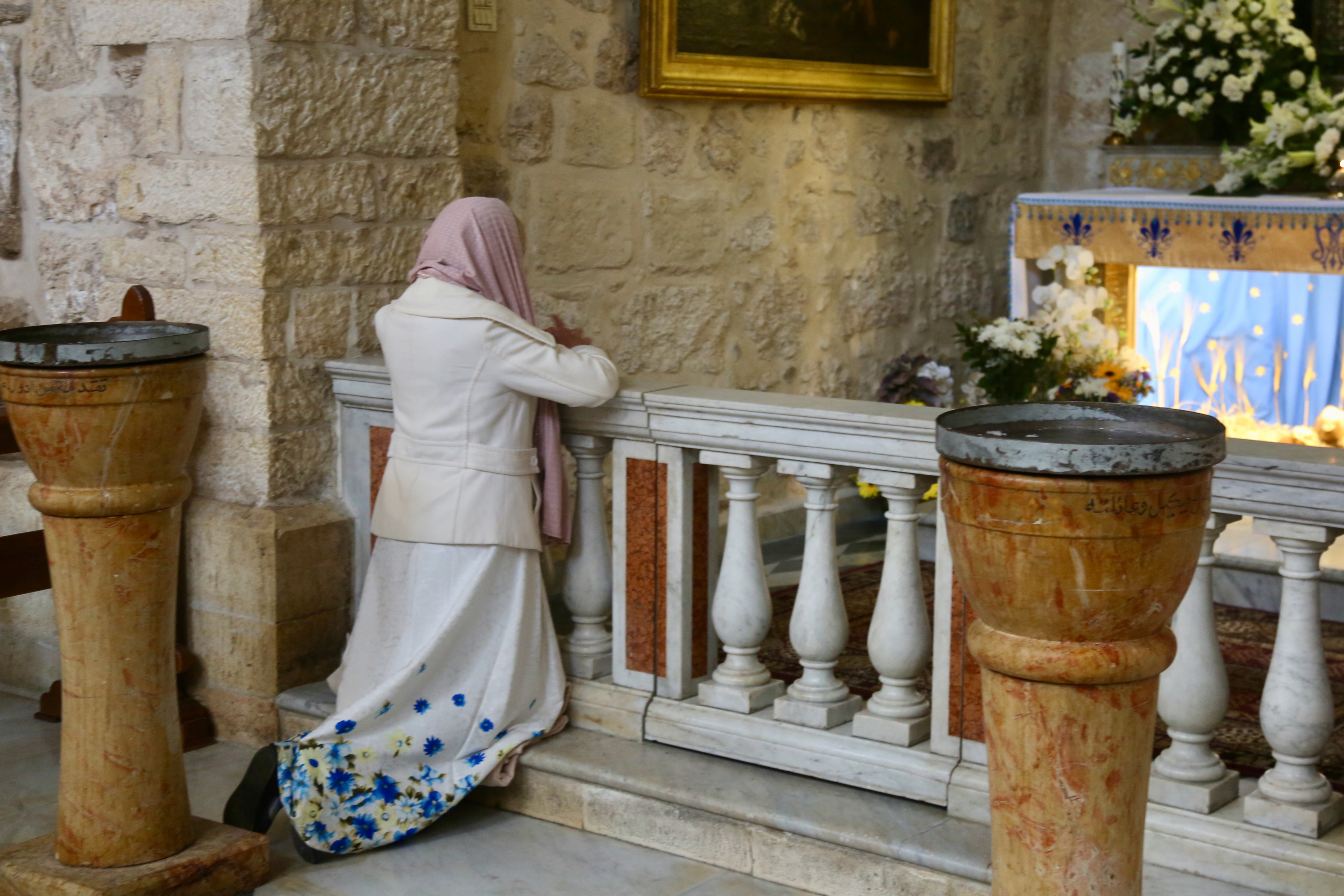 A woman prays inside the Church of the Nativity, Bethlehem. Photo: Ian Lloyd Neubauer