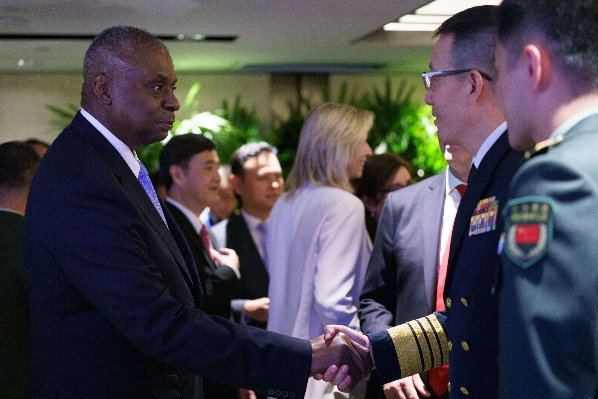 Lloyd Austin, US secretary of defense, left, shakes hands with Dong Jun, China’s defense minister, on the sidelines of the IISS Shangri-La Dialogue in Singapore on Saturday. Photo: Bloomberg