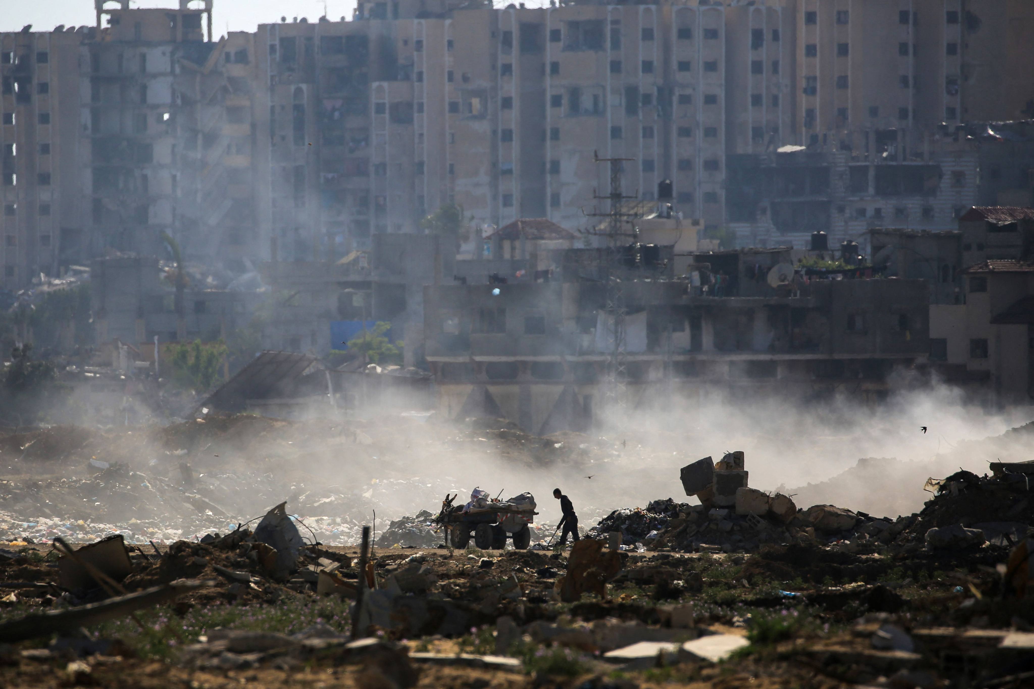 A Palestinian man salvages items atop of building rubble at al-Bureij camp in the central Gaza Strip. Photo: AFP