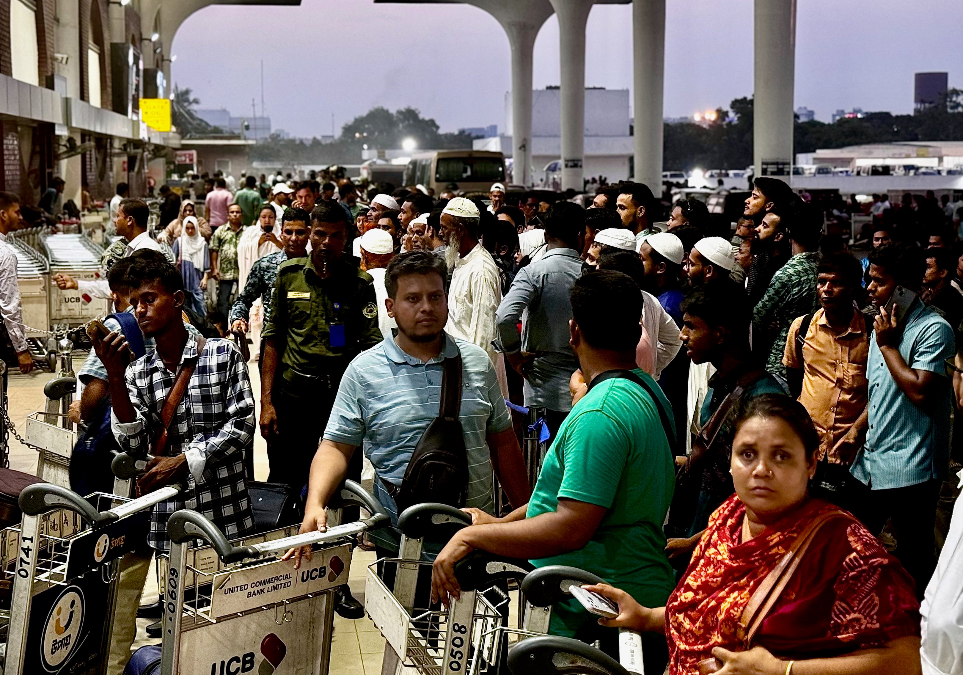 Prospective migrants and their families gather outside Dhaka airport last Friday, awaiting updates about their tickets. Photo: Redwan Ahmed