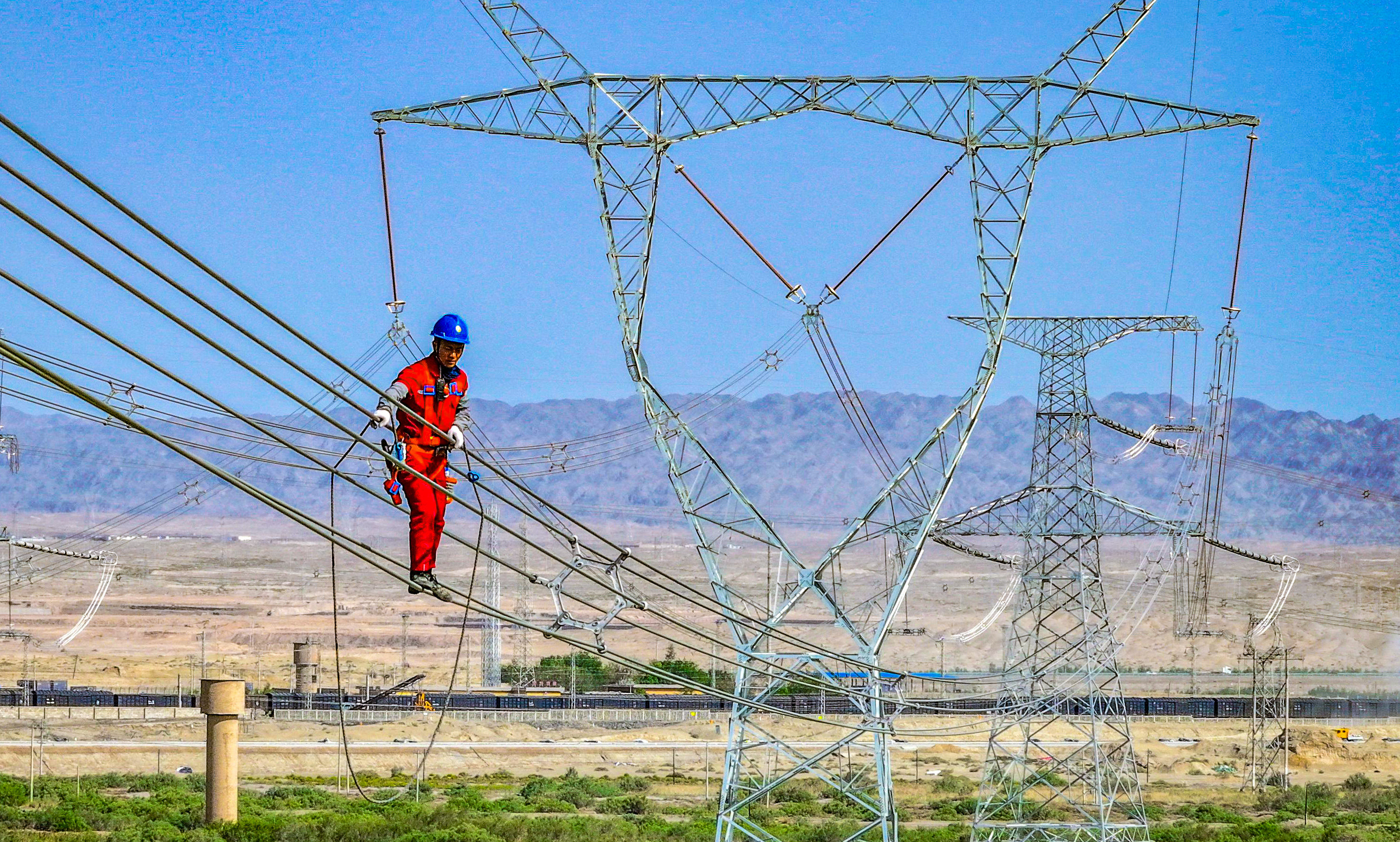 This photo taken on May 23, 2024 shows a worker installing electricity transmission lines in Korla, in China’s northwestern Xinjiang region. Photo: AFP