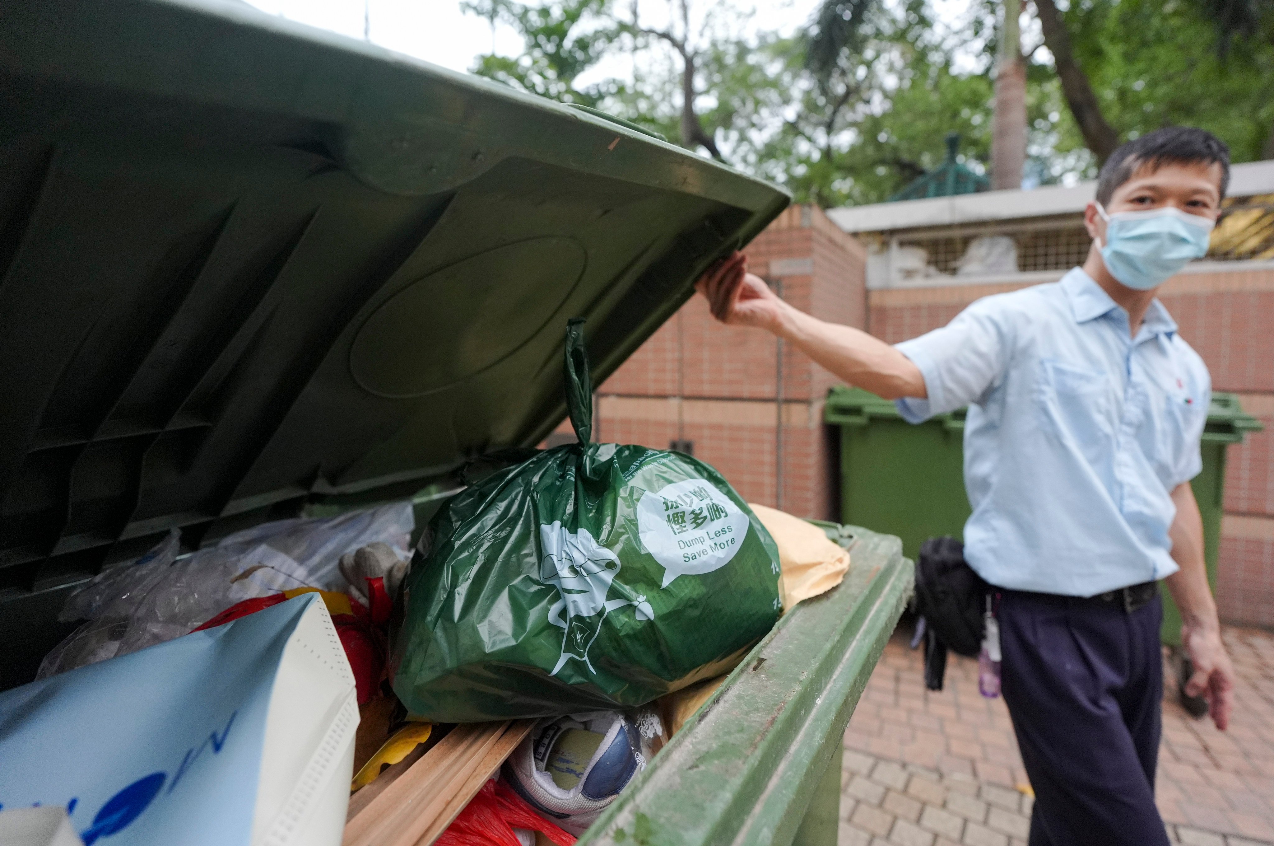 A resident uses a designated trash bag outside On Ning House in Tsuen Wan on April 1, during the test run of the waste-charging scheme. Hong Kong has shelved the plan without a timeline for relaunching it. Photo: Eugene Lee 