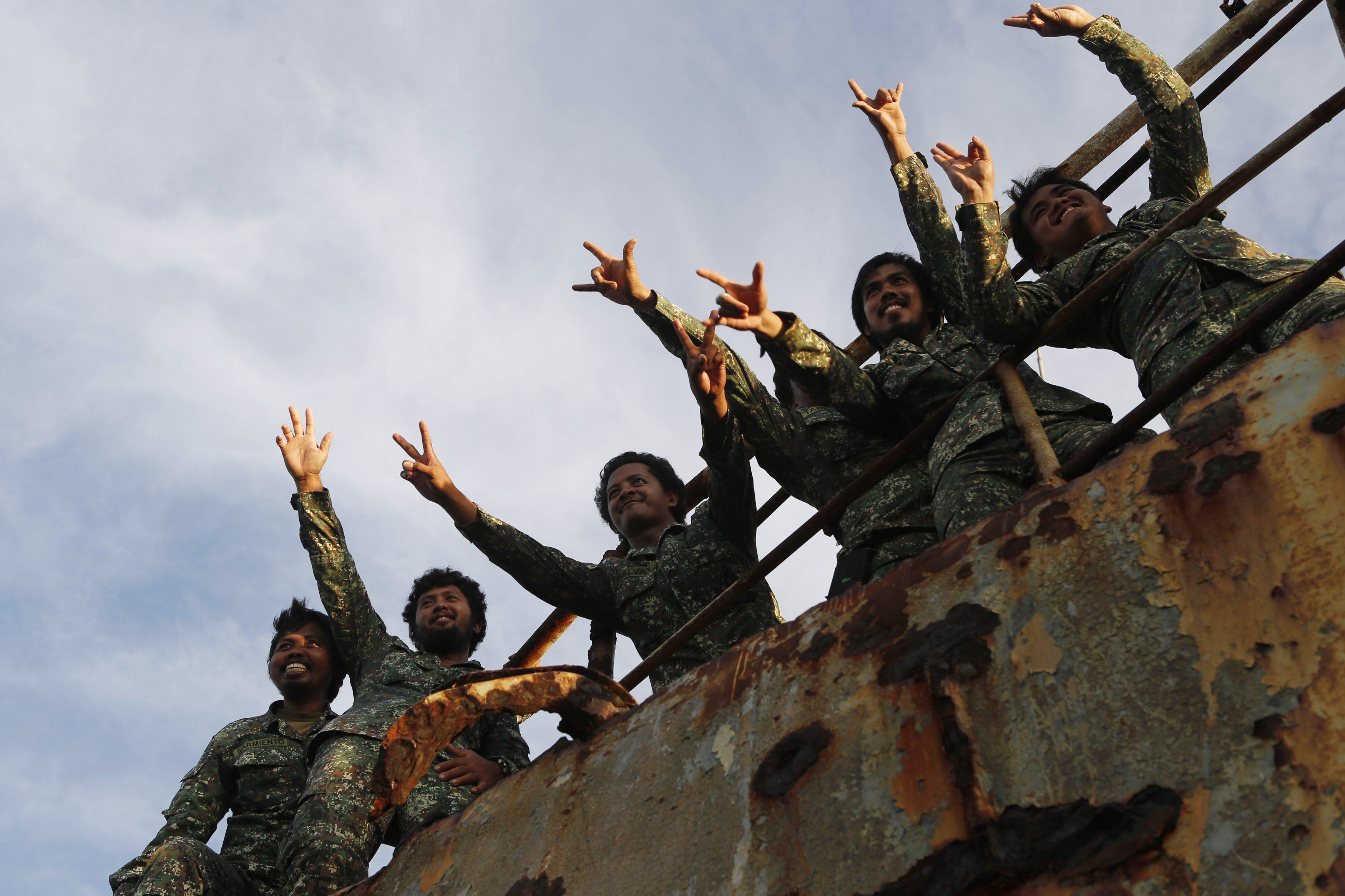 Philippine Marine Corps servicemen stationed aboard the BRP Sierra Madre gesture to reporters at the disputed Second Thomas Shoal in the South China Sea. Photo: Reuters