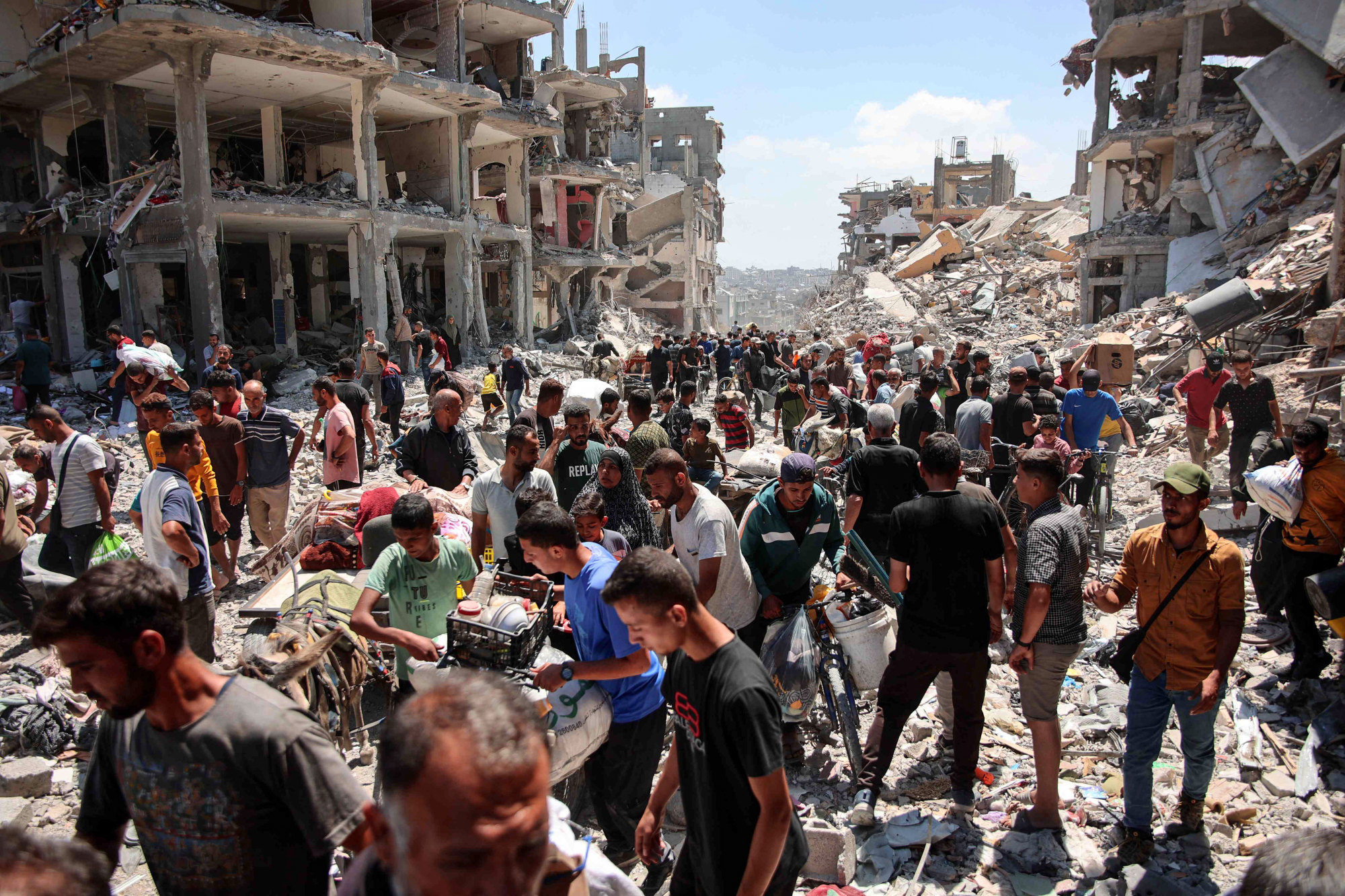 Palestinians carry salvaged belongings as they leave the Jabalia refugee camp in the northern Gaza Strip amid the ongoing conflict between Israel and the militant group Hamas. Photo: AFP