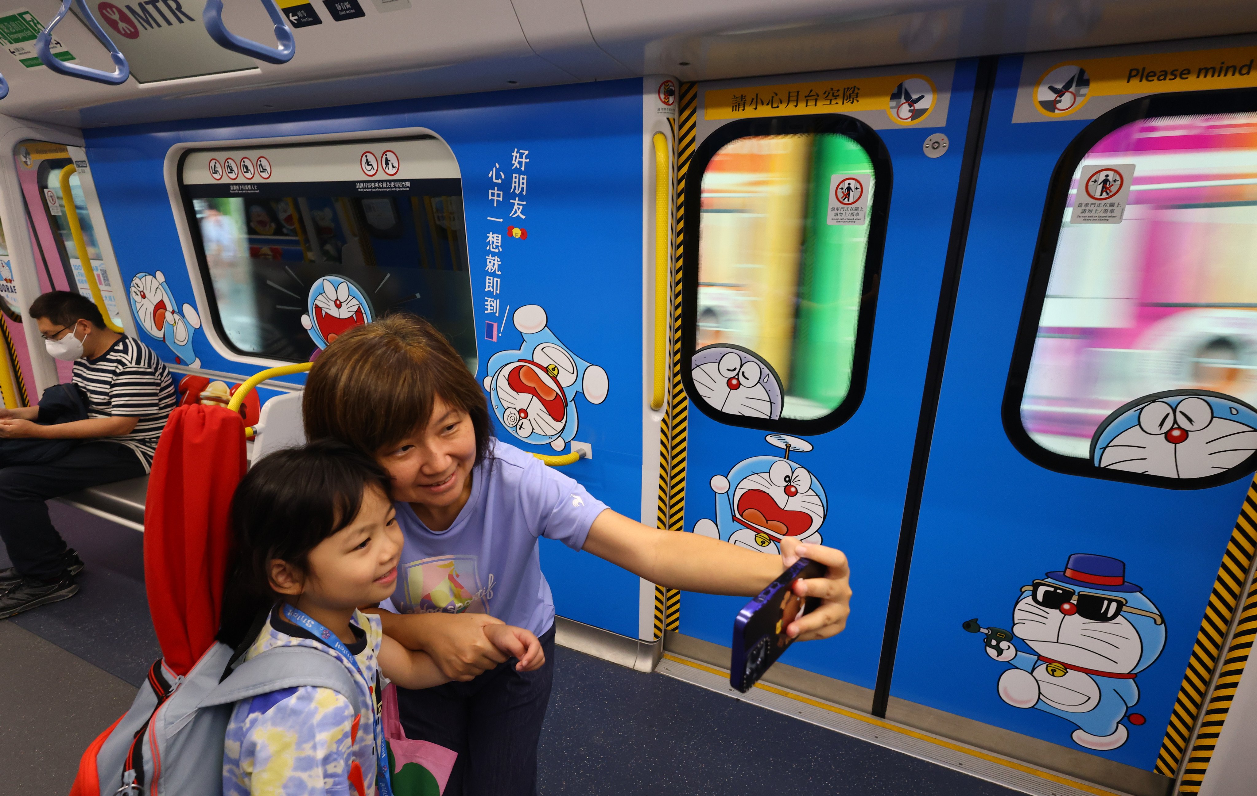 Passengers take a selfie on a Doraemon-themed MTR train on the East Rail Line in Hong Kong on June 1. Photo: Dickson Lee