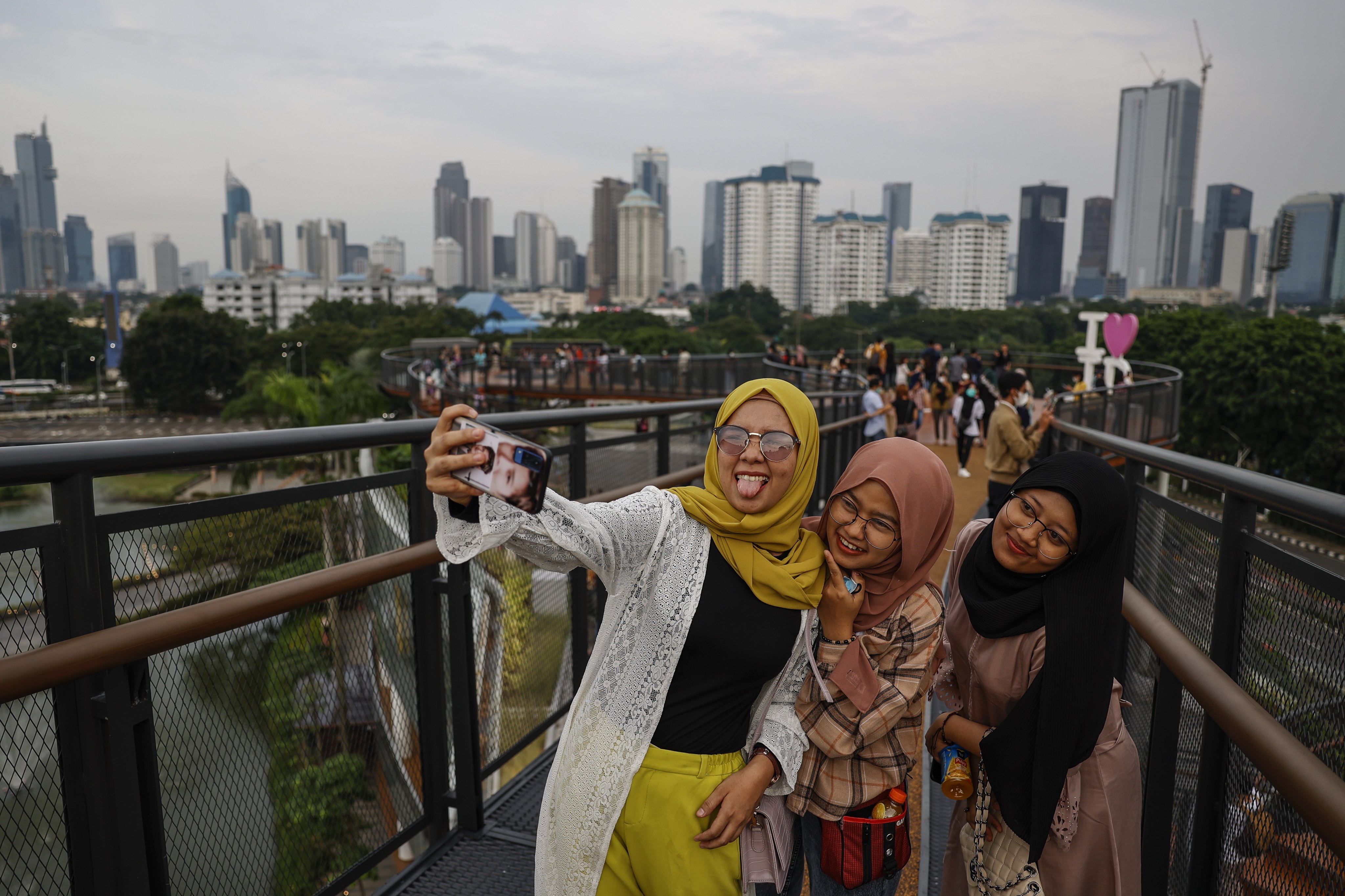Teenagers take a selfie on a skywalk in Jakarta in 2021. With a youthful demographic eager to embrace new technologies and an internet economy projected to pass US$300 billion by 2025, Southeast Asia is a vast market ripe for disruption and growth. Photo: EPA-EFE