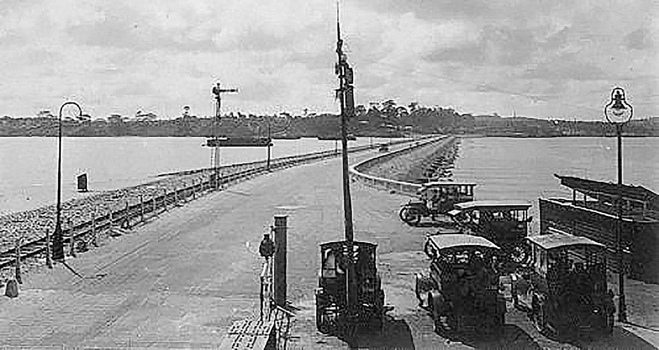 Small seven-seater buses “mosquito buses” wait for customers at the Johor end of the causeway to Singapore in the 1920s. Photo: Handout