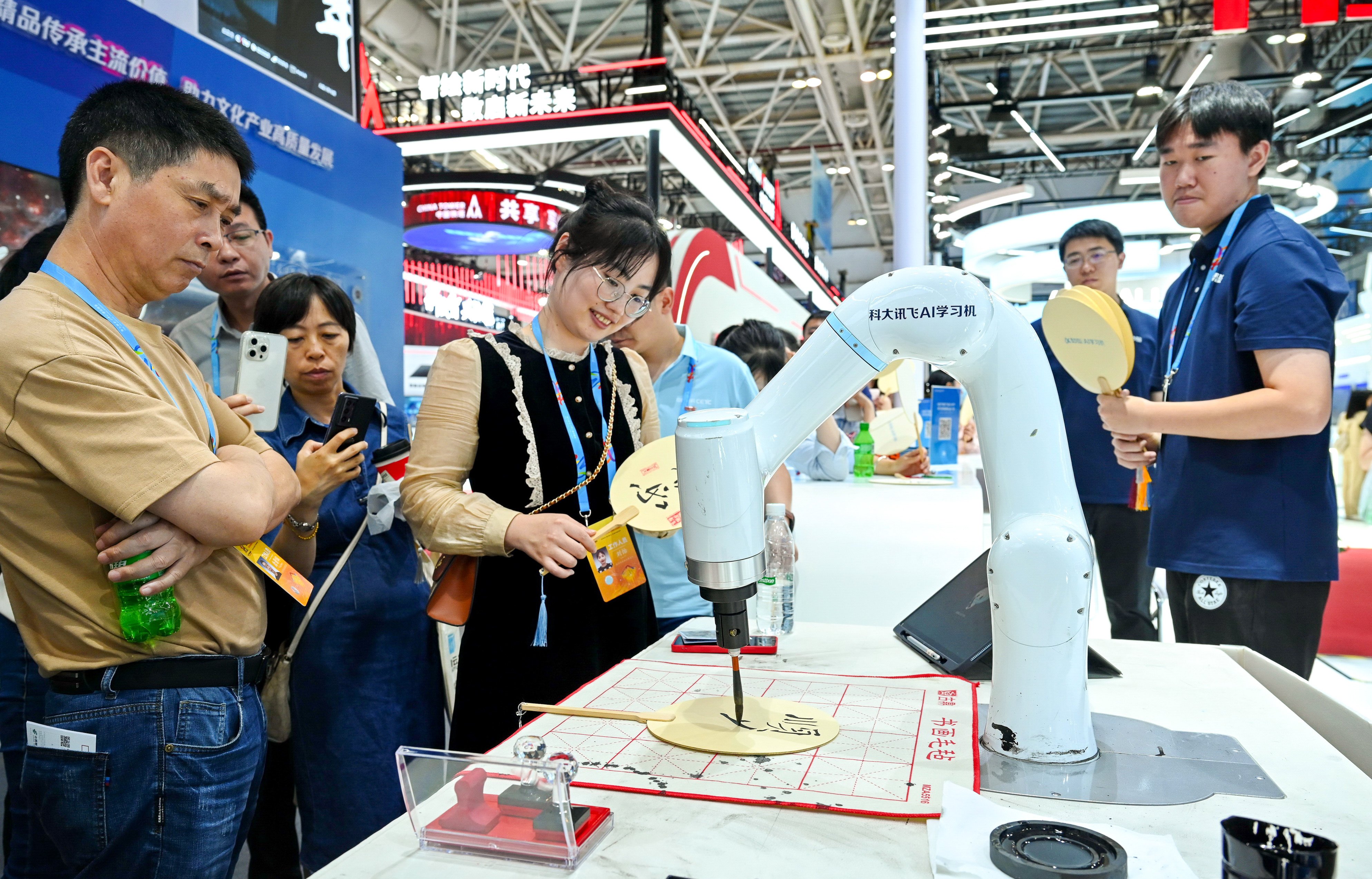 A calligraphy robot decorates a fan at the 7th Digital China Summit in the southeastern city of Fuzhou on May 24. China has been rapidly advancing its AI capabilities to compete against the US. Photo: Xinhua
