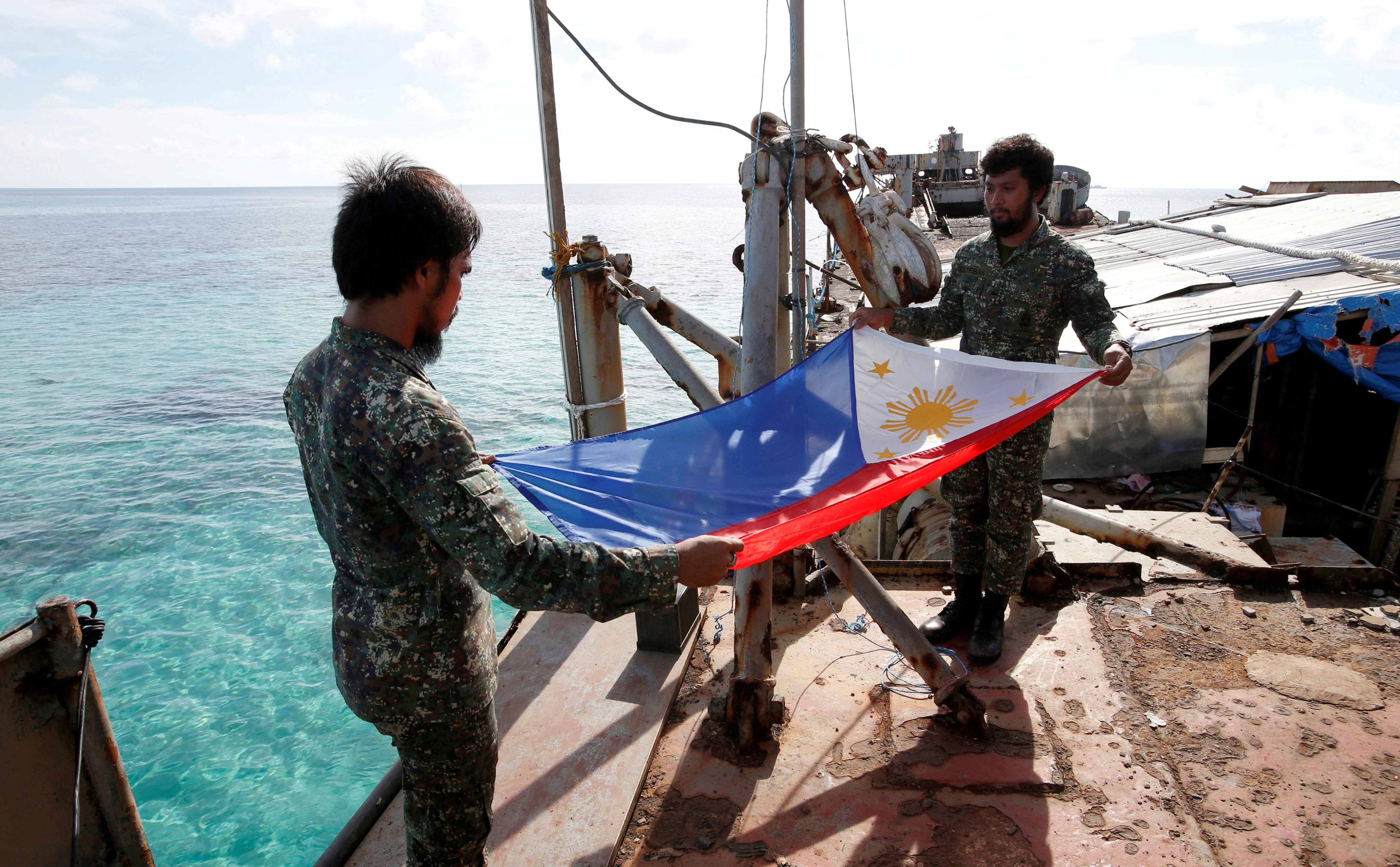 Philippine marines fold their national flag during a flag retreat at the BRP Sierra Madre, a marooned transport ship in the disputed Second Thomas Shoal. Photo: Reuters