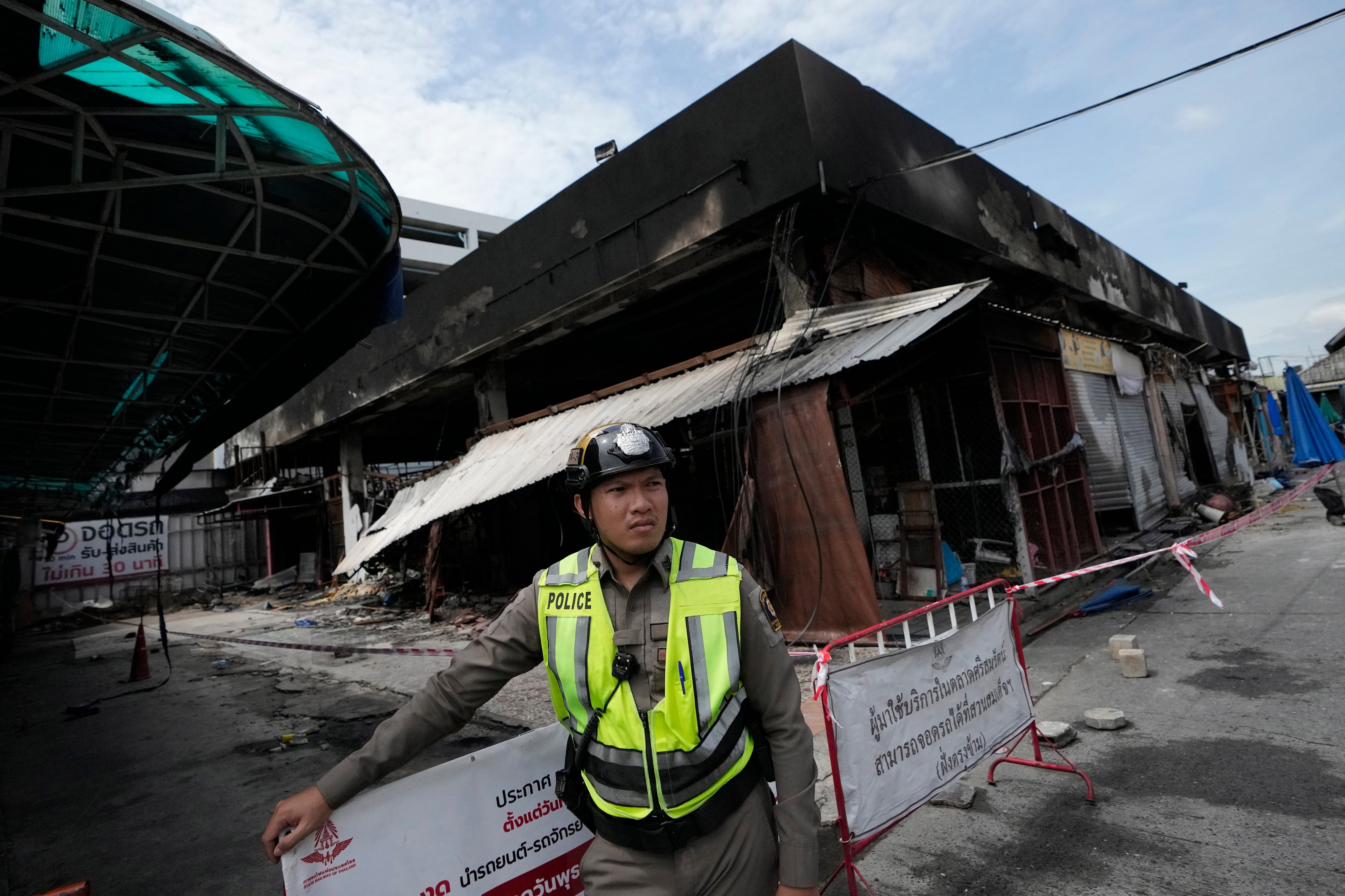 A Thai officer stands by the pet zone area after a fire at Chatuchak Weekend Market, one of the most famous markets in Bangkok, on Tuesday. Photo: AP