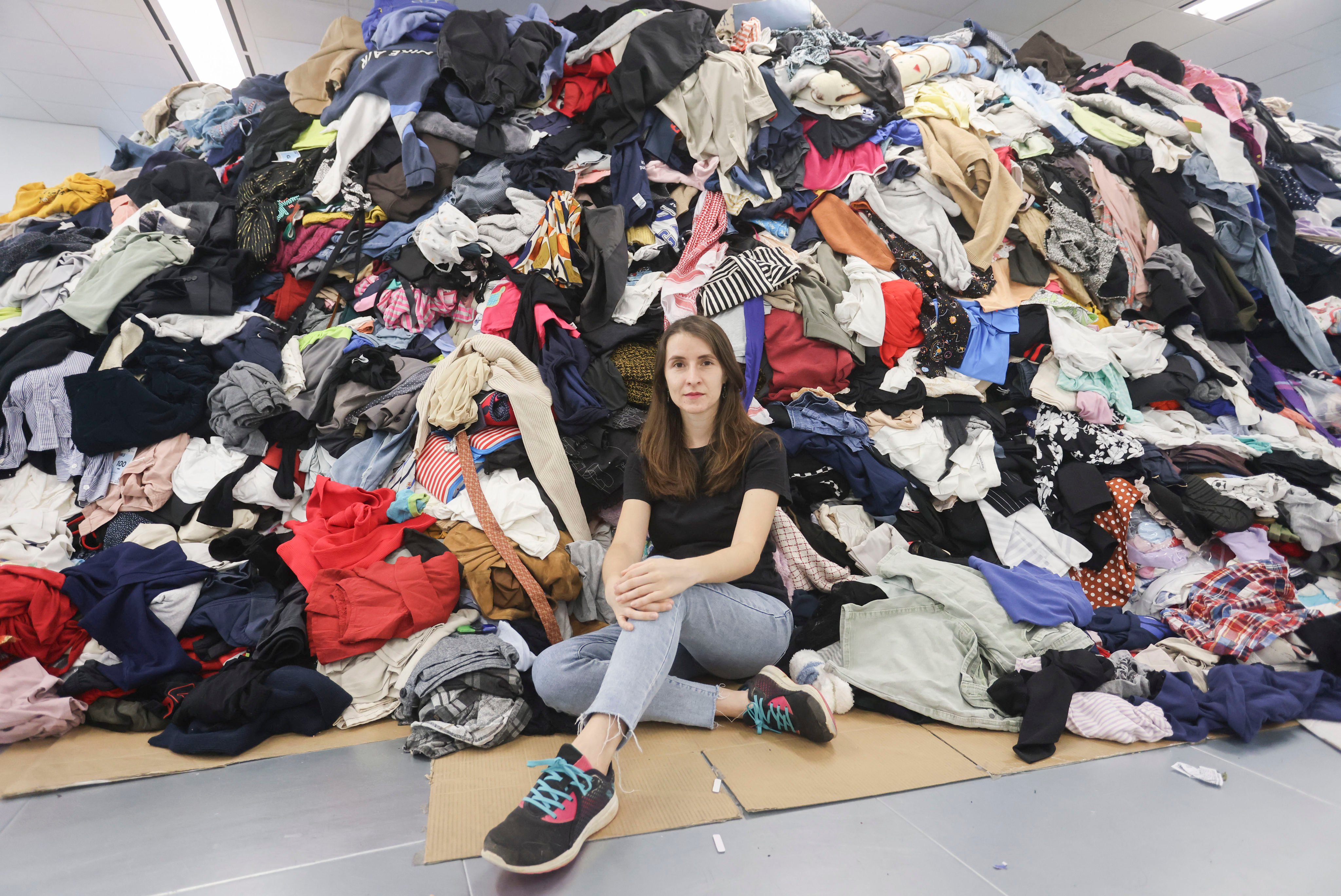 Redress’ Aurianne Ricquier with a mountain of clothes from a month-long donation drive in Hong Kong. The charity will repurpose, resell, repair and recycle what it can – saving the clothes from landfill. Photo: Jonathan Wong