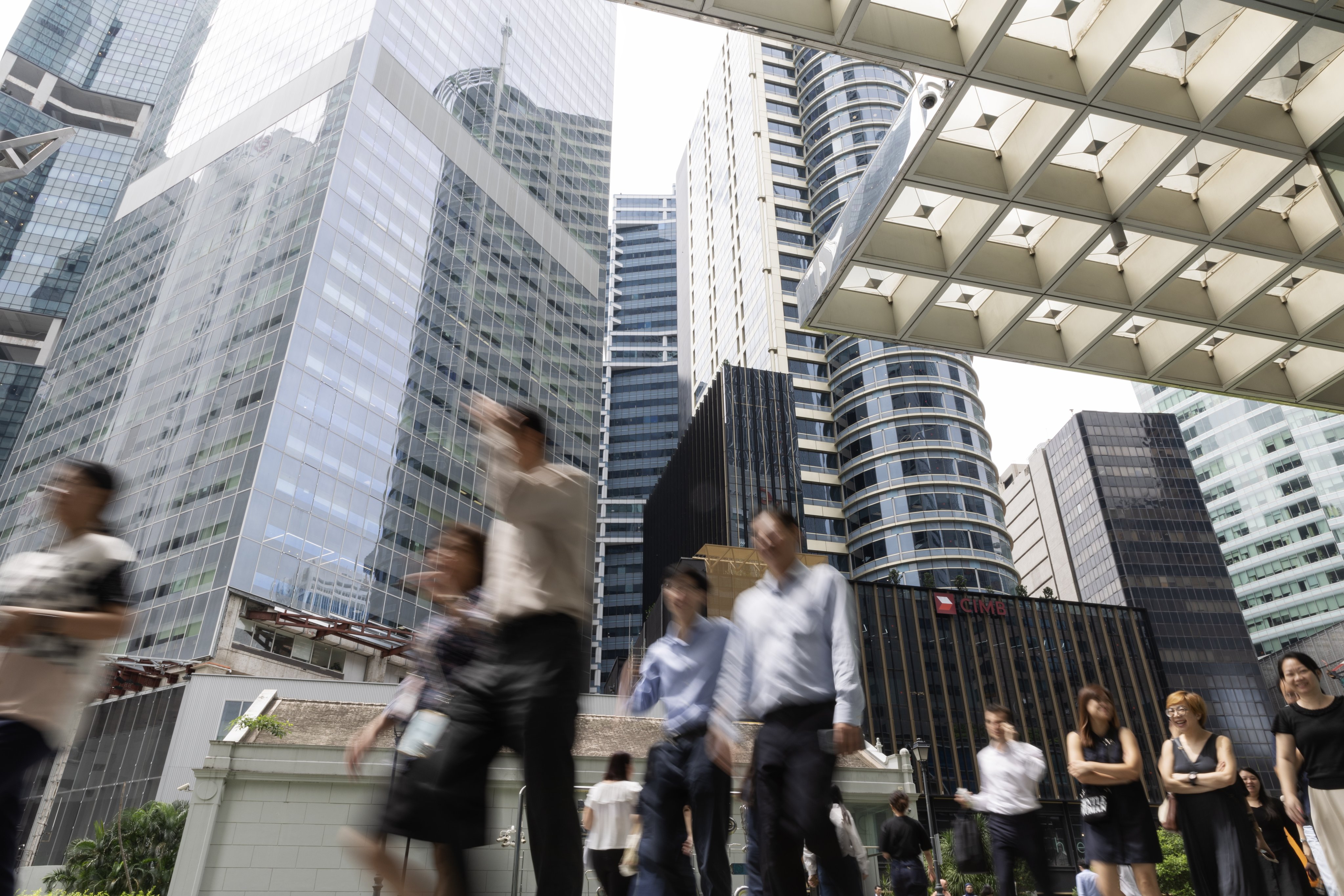 People walk in Singapore’s central business district. About 1.77 million of the city state’s 5.92 million people are foreign workers, their dependants, international students and other non-residents. Photo: EPA-EFE