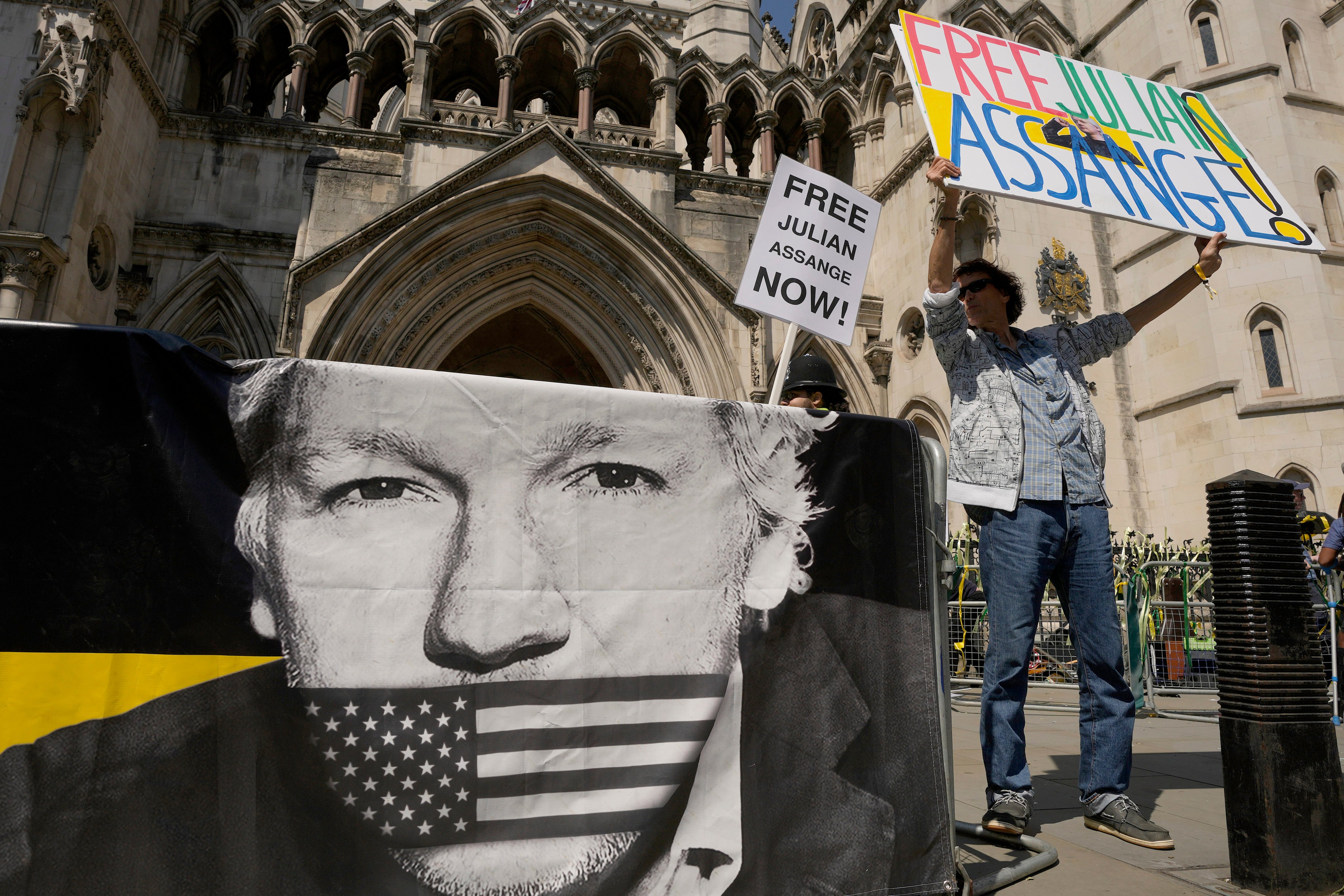 A protester stands outside the High Court in London A British court has ruled that WikiLeaks founder Julian Assange can appeal against an order that he be extradited to the US on espionage charges. Photo: AP