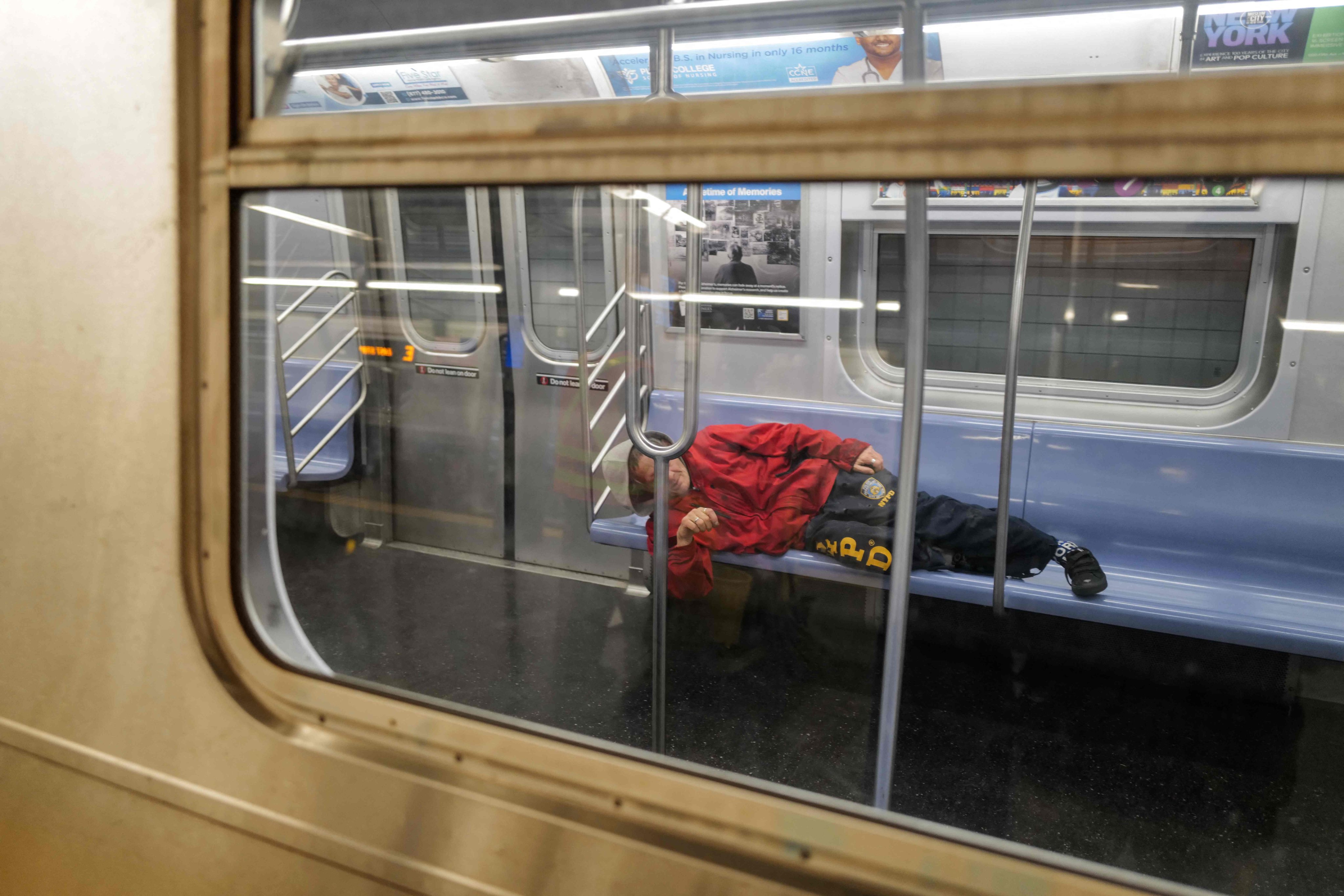 A homeless person sleeps in a subway car at night in the Manhattan district of New York City on December 13, 2023. Photo: AFP