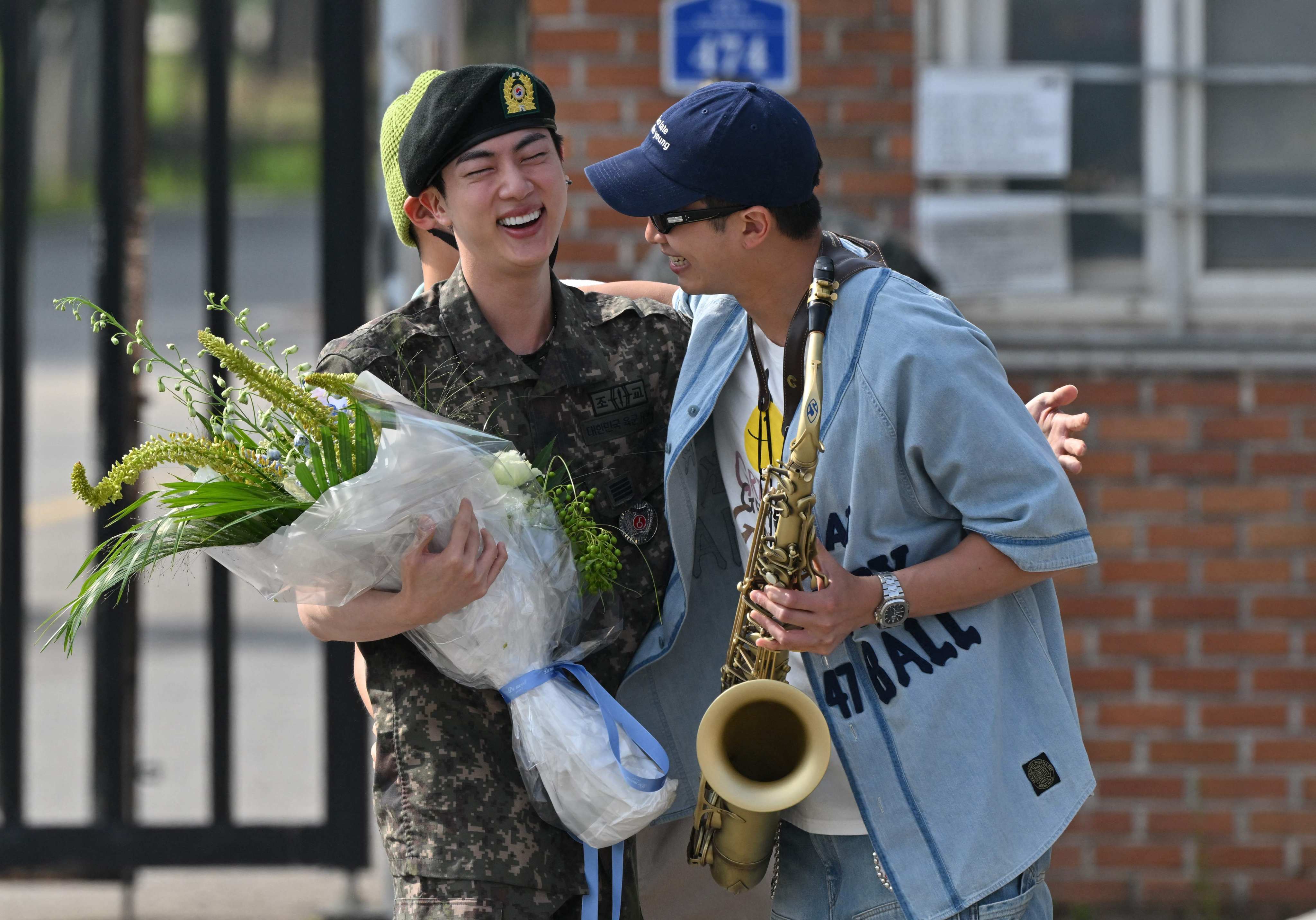 K-pop boy band BTS member Jin is greeted by fellow BTS member RM after being discharged from his mandatory military service outside a base in Yeoncheon on Wednesday. Photo: AFP