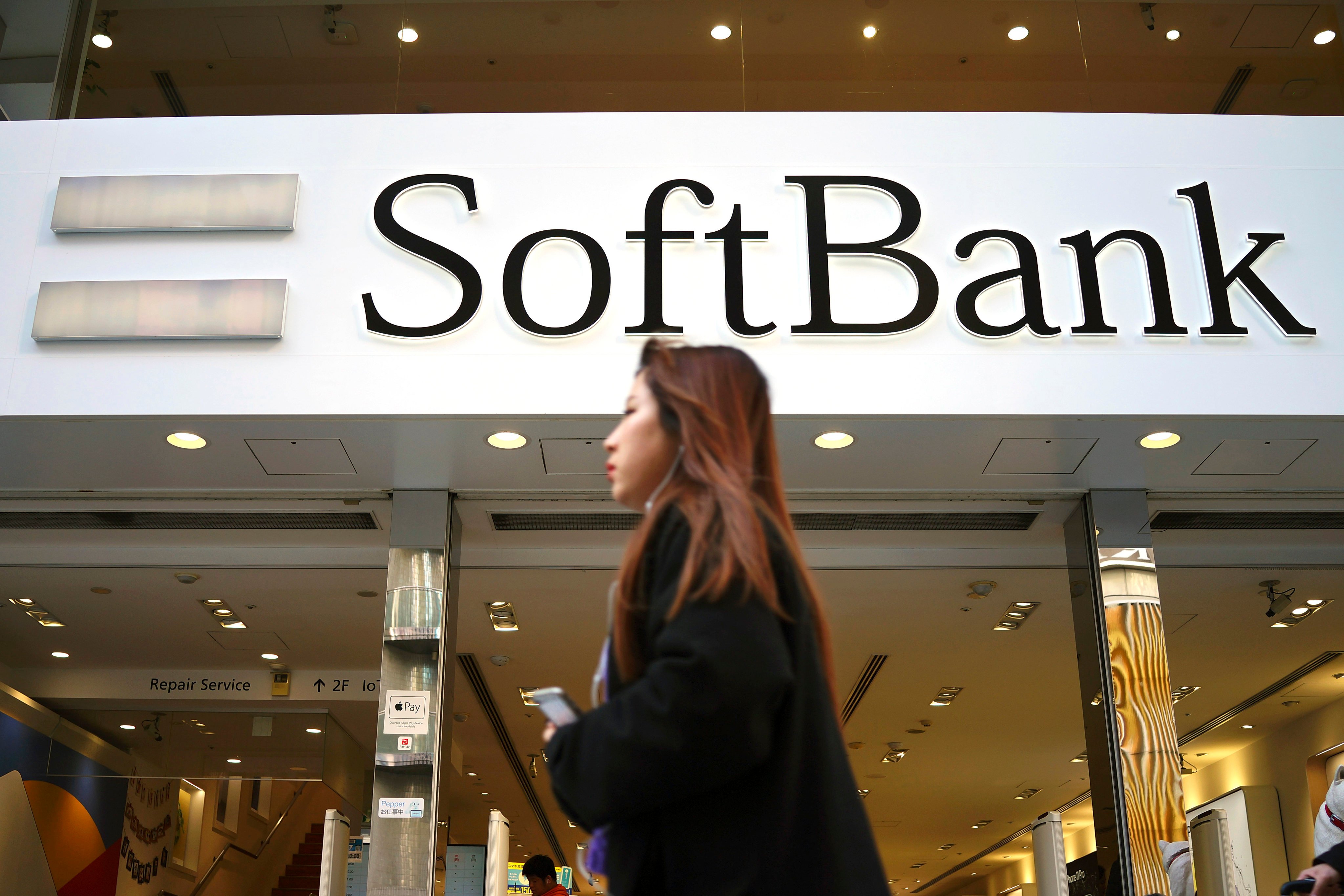 A woman walks in front of a SoftBank store in Ginza shopping district in Tokyo. File photo: AP
