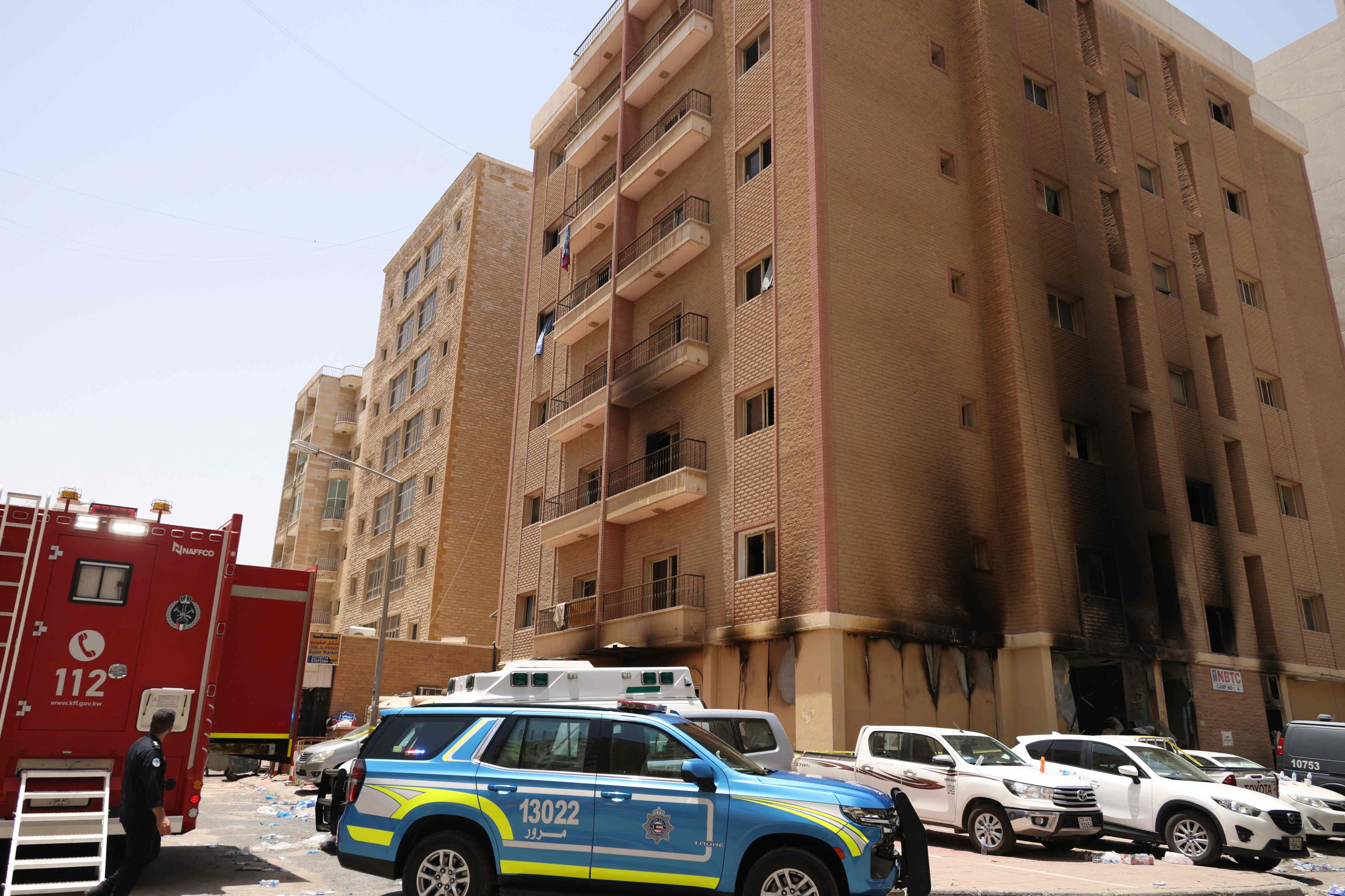 Firefighters and security forces gather outside the blaze-hit building in Kuwait City on June 12. Photo: AFP
