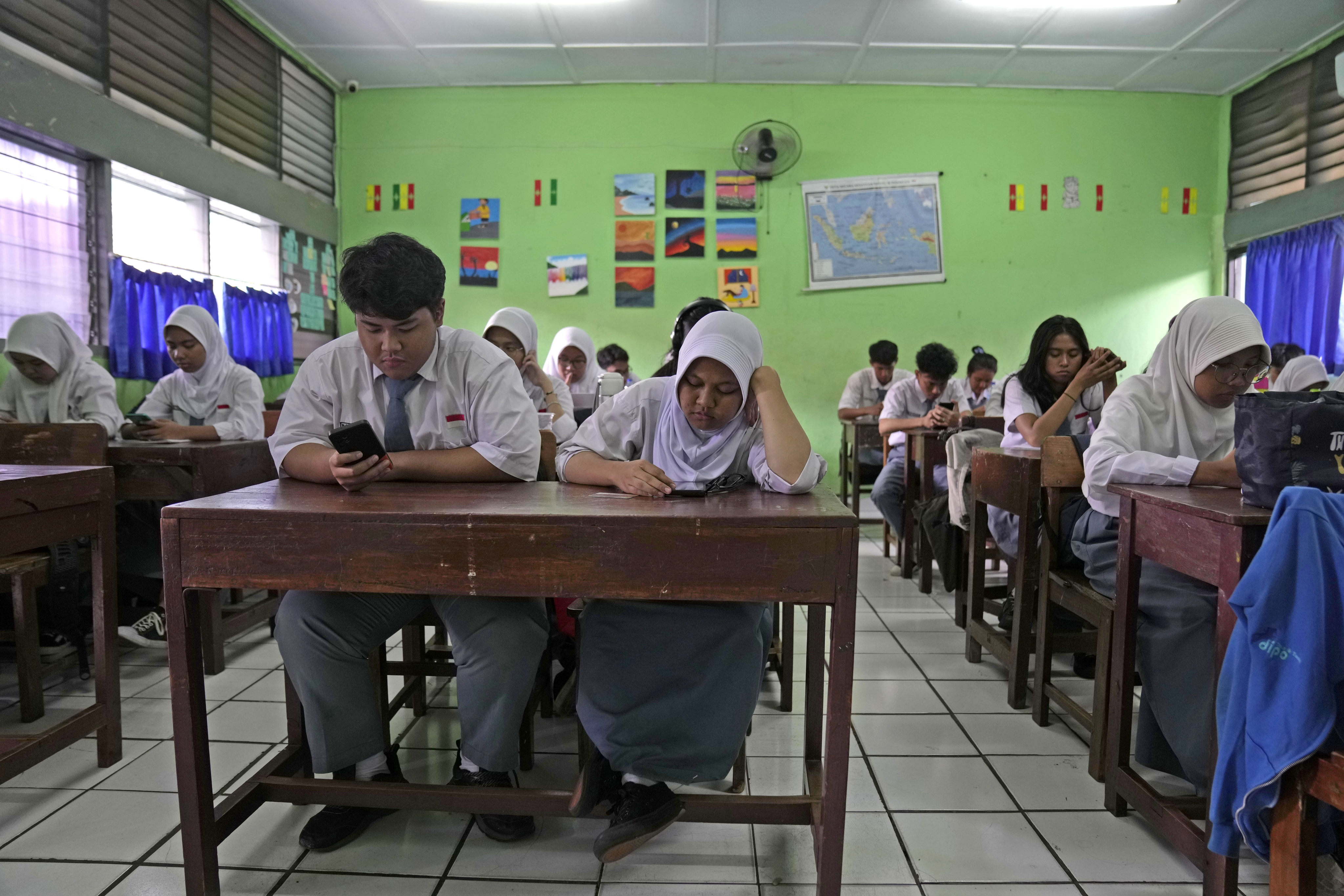 Students use their mobile phones to work on an online exercise at a high school in Jakarta, Indonesia, in January. Photo: AP