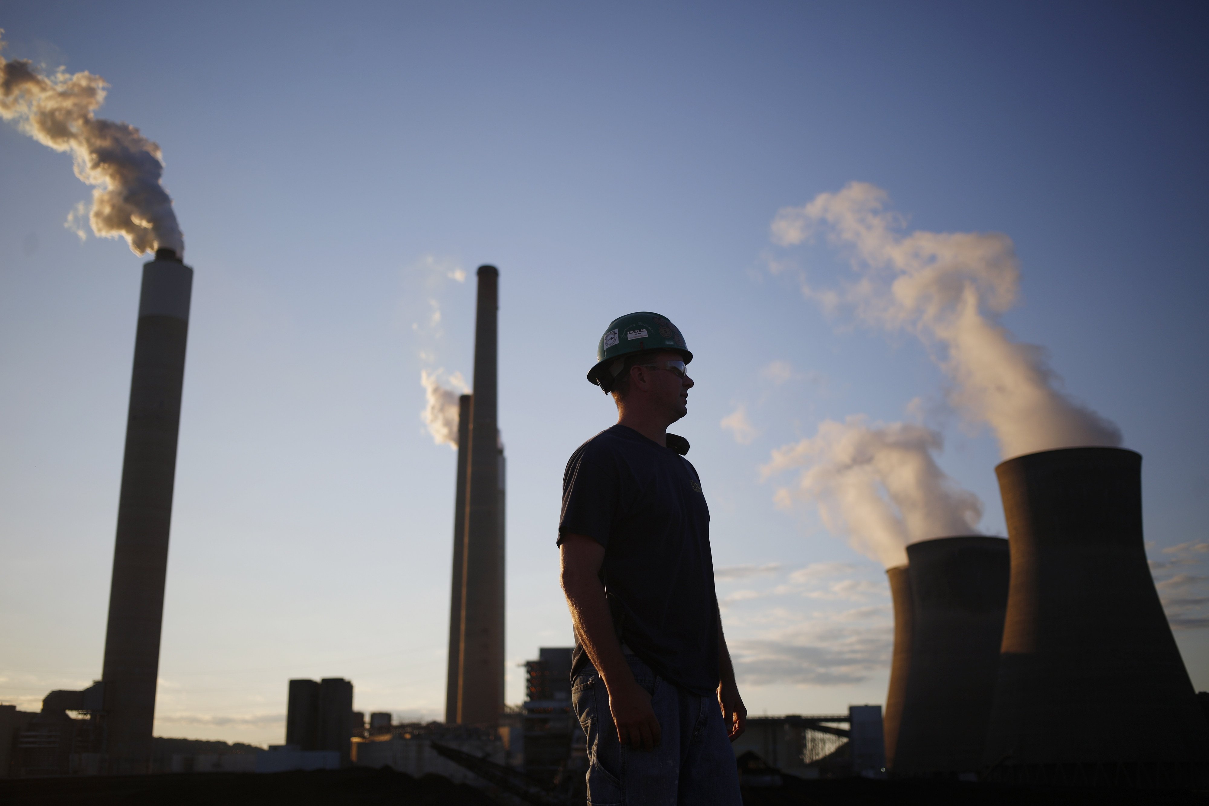 A worker stands in the yard of a coal-fired power station in Winfield, West Virginia, in July 2018. There is an urgent need to replace coal- and oil-fired power generation with renewables or nuclear energy, and to finance the vast transition costs involved. Photo: Bloomberg
