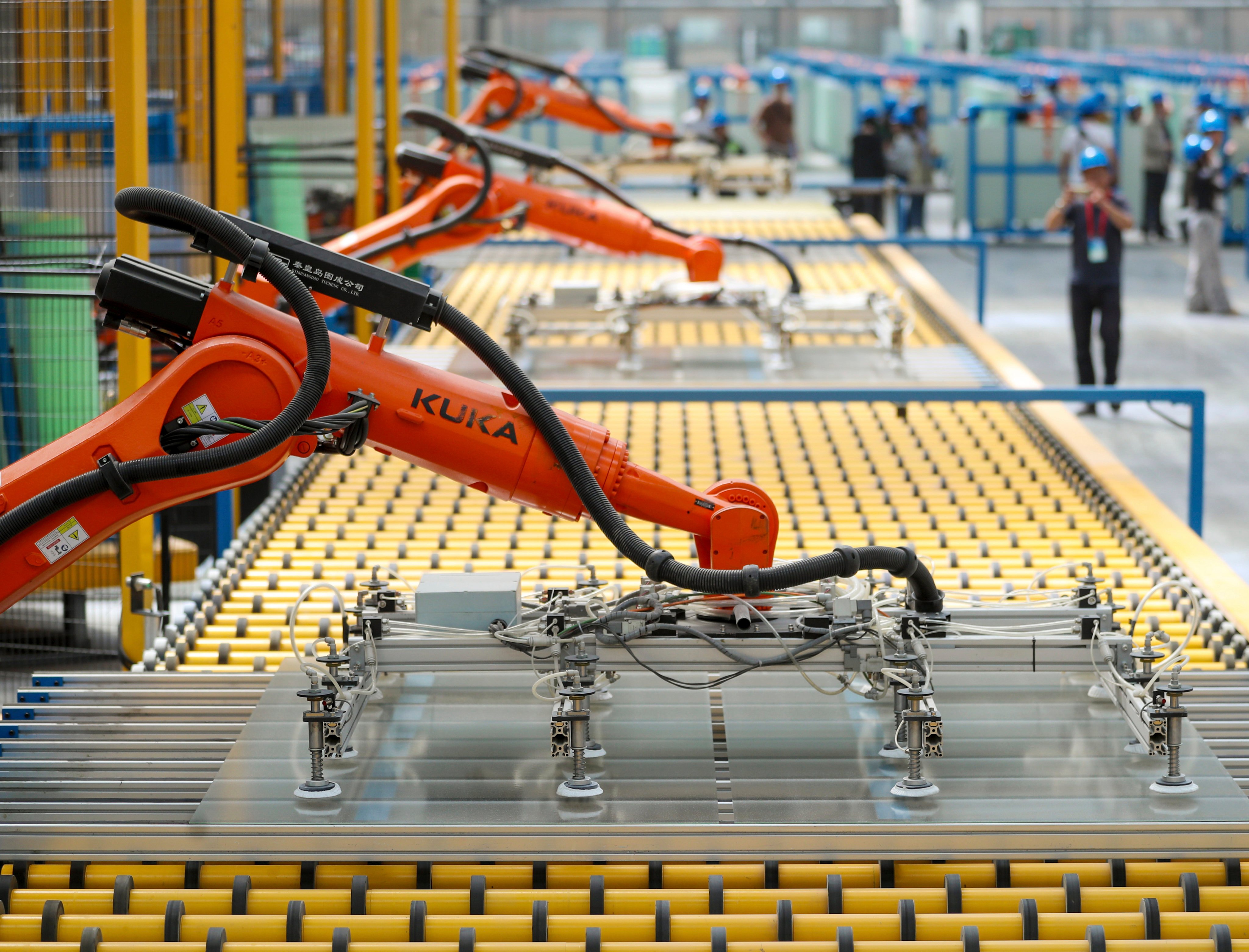 Kuka robots work on the production line of flat glass for solar panels at a subsidiary plant of Hoshine Silicon Industry in northwestern China’s Xinjiang Uyghur Autonomous Region. China’s statistics bureau is due to announce industrial production, retail sales and fixed-asset investment data for May on Monday Photo: AP