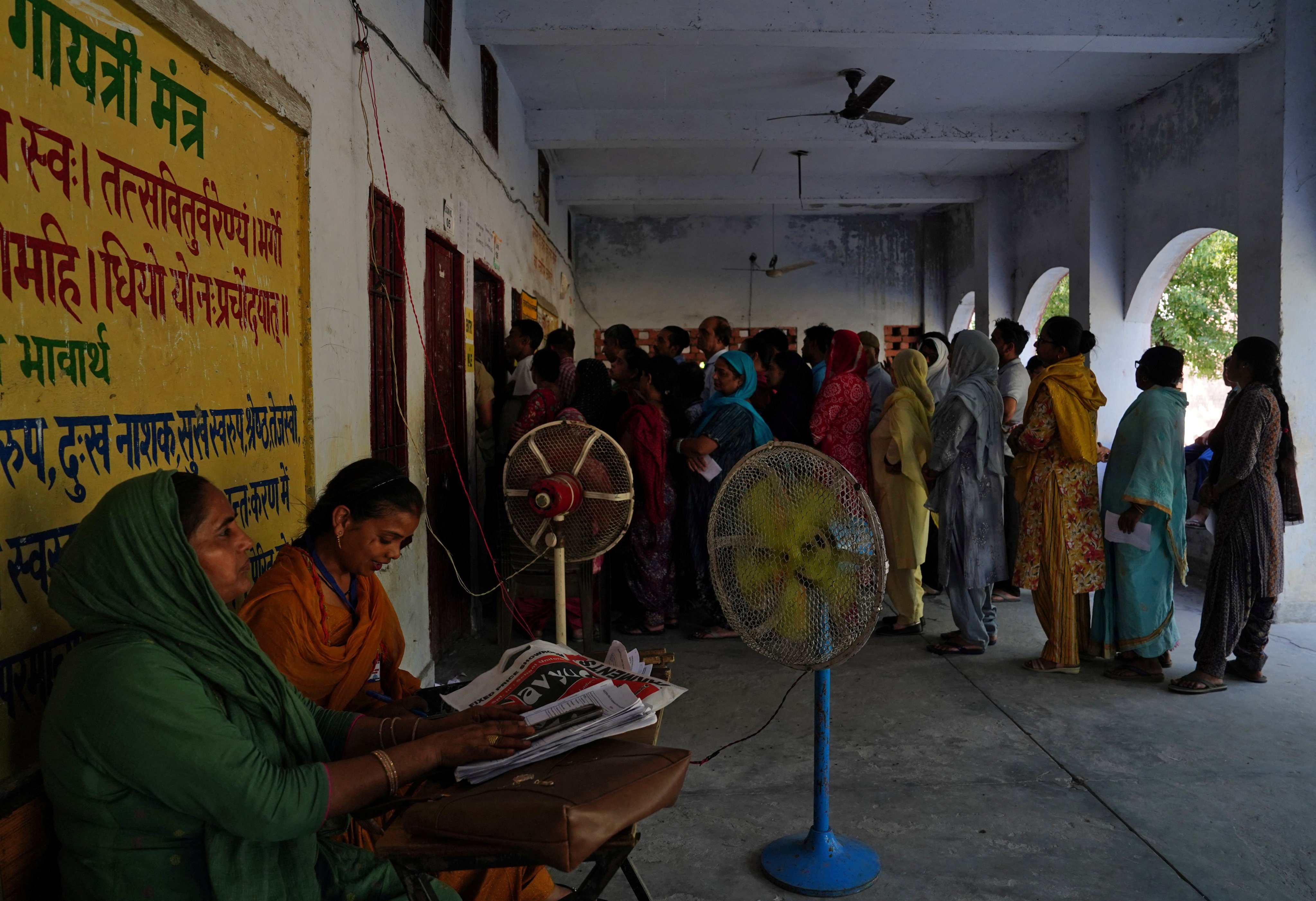 Fans keep voters cool as they wait in line to cast their votes at a polling station on a hot summer day in Karnal, in the northern state of Haryana, India, on May 25. Photo: Reuters