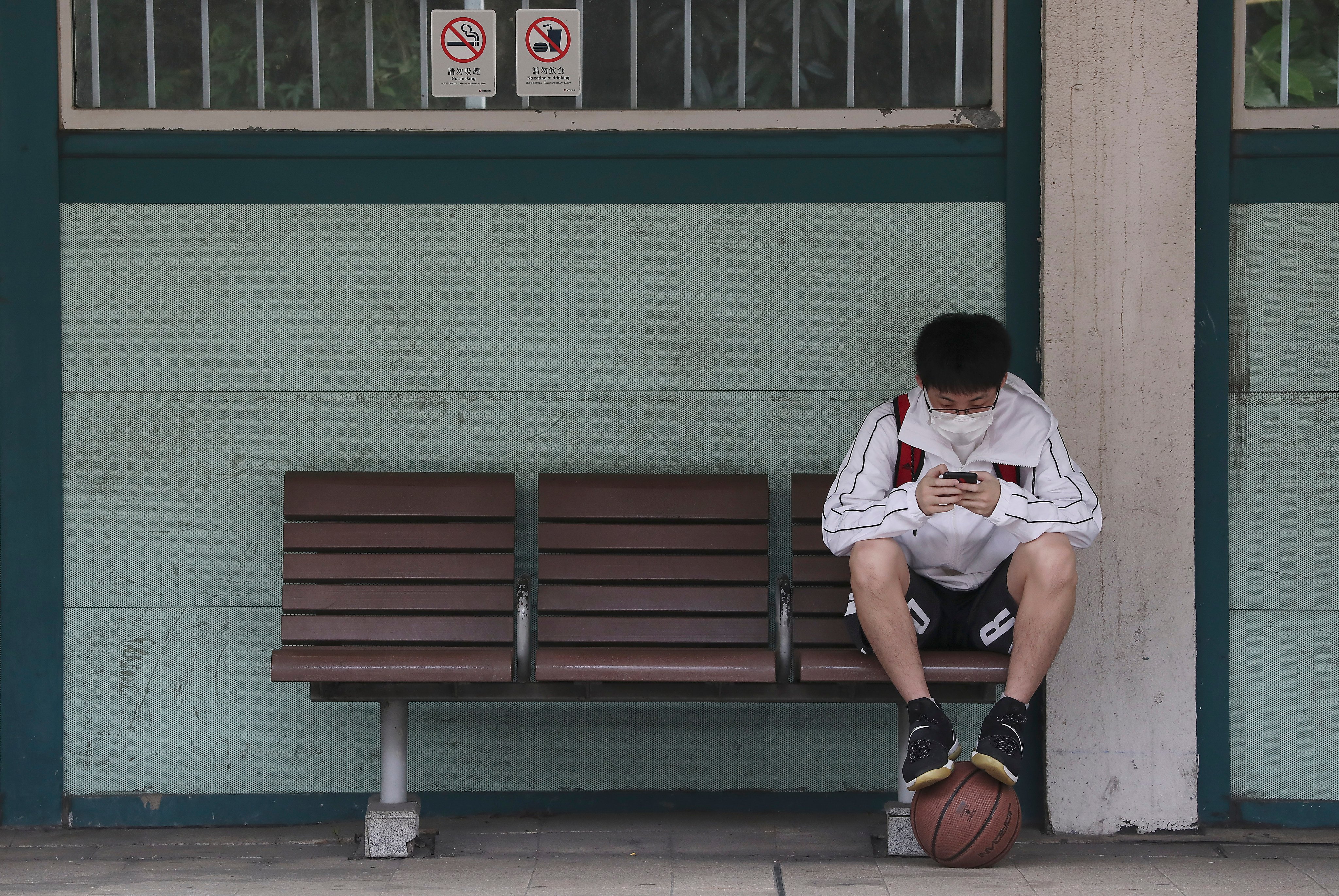 A student uses a mobile device at Kowloon Tong MTR station in 2020. Photo: Jonathan Wong