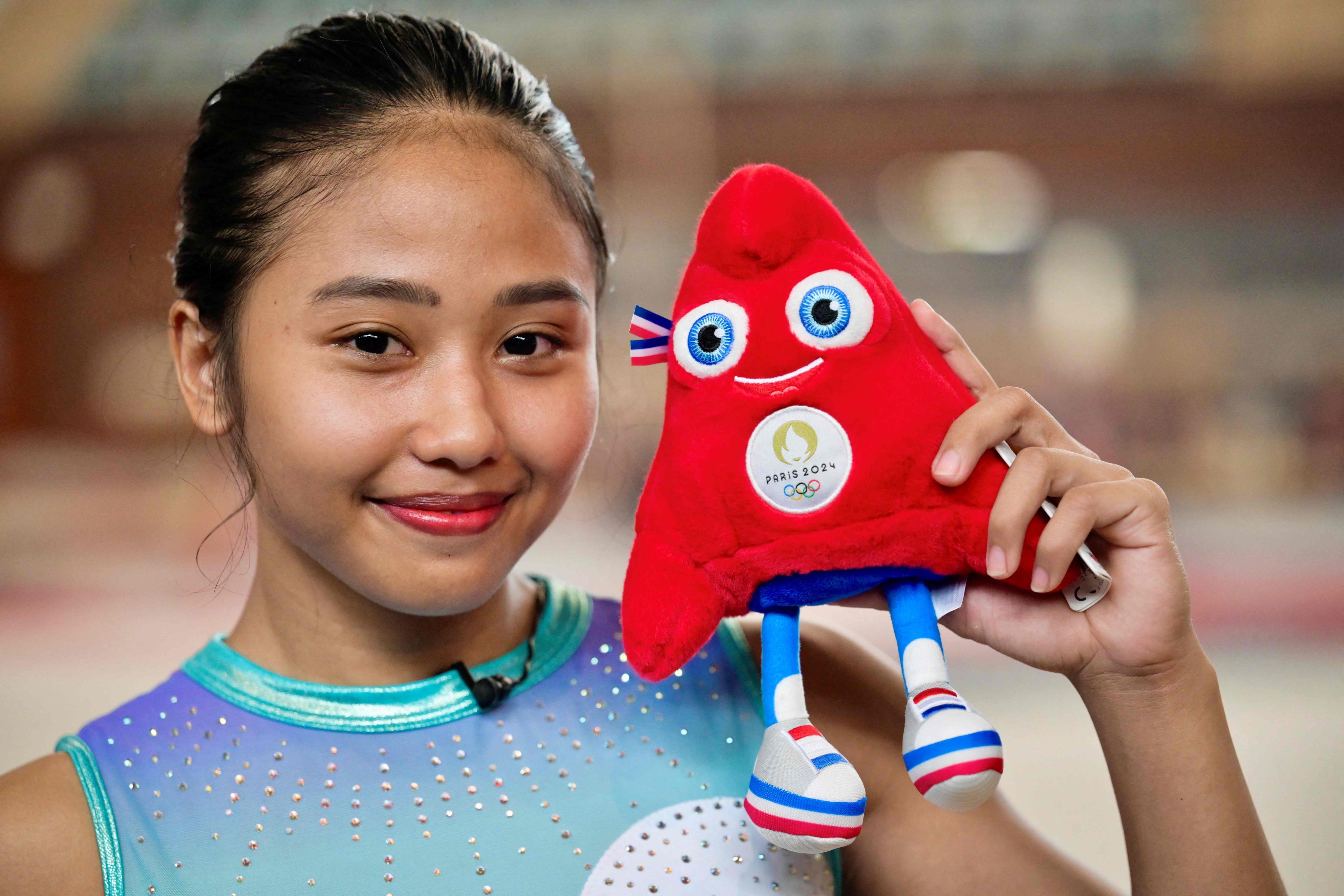 Rifda Irfanaluthfi, the first Indonesian gymnast to qualify for the Olympics, with a Paris Games mascot. Photo: AFP
