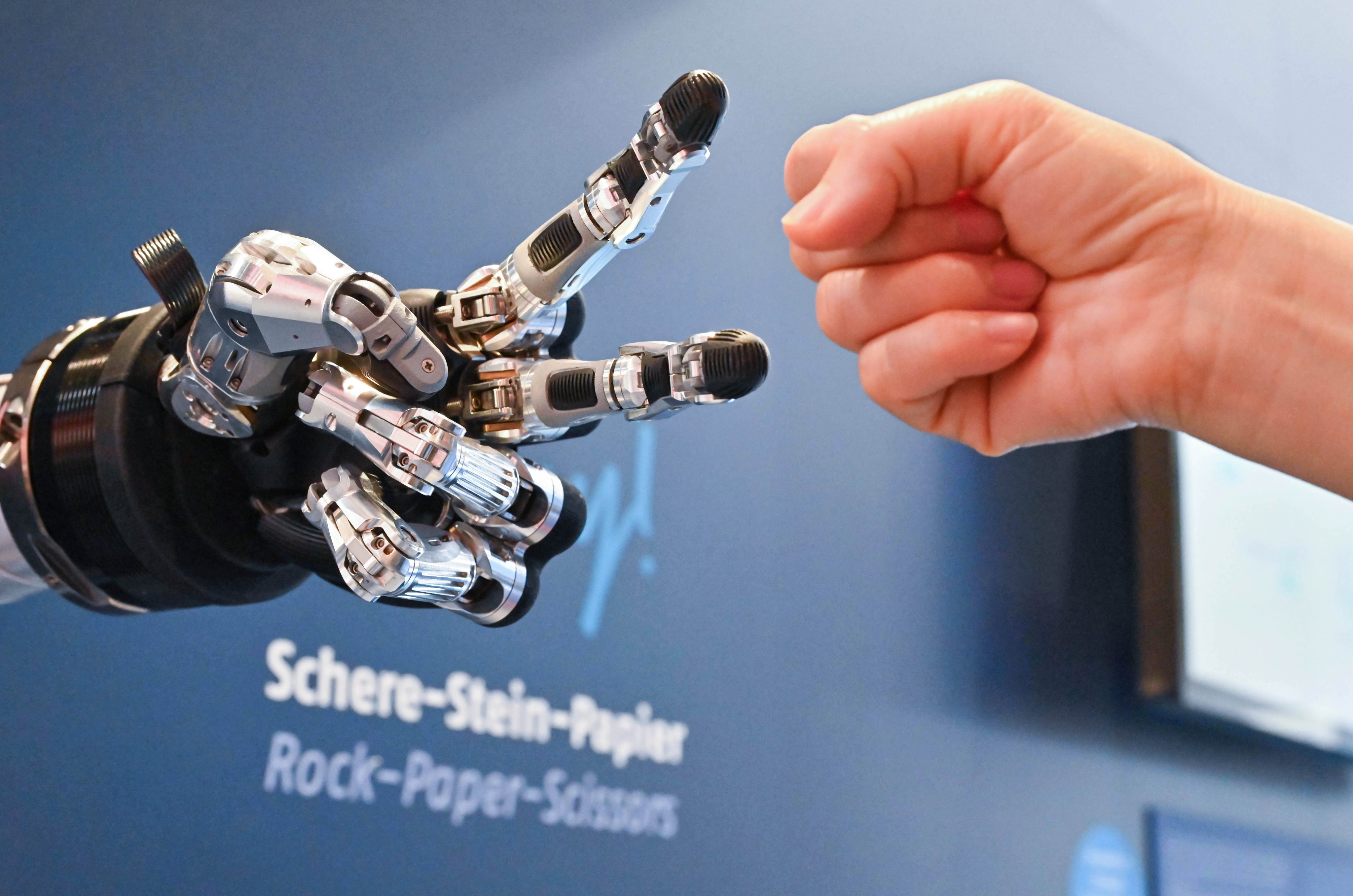 A visitor plays “rock, paper, scissors” with a robot at Hannover Messe, an industrial trade fair, in Germany, on April 23. The artificial innovation revolution will leave behind countries and companies which fail to adapt. Photo: Xinhua