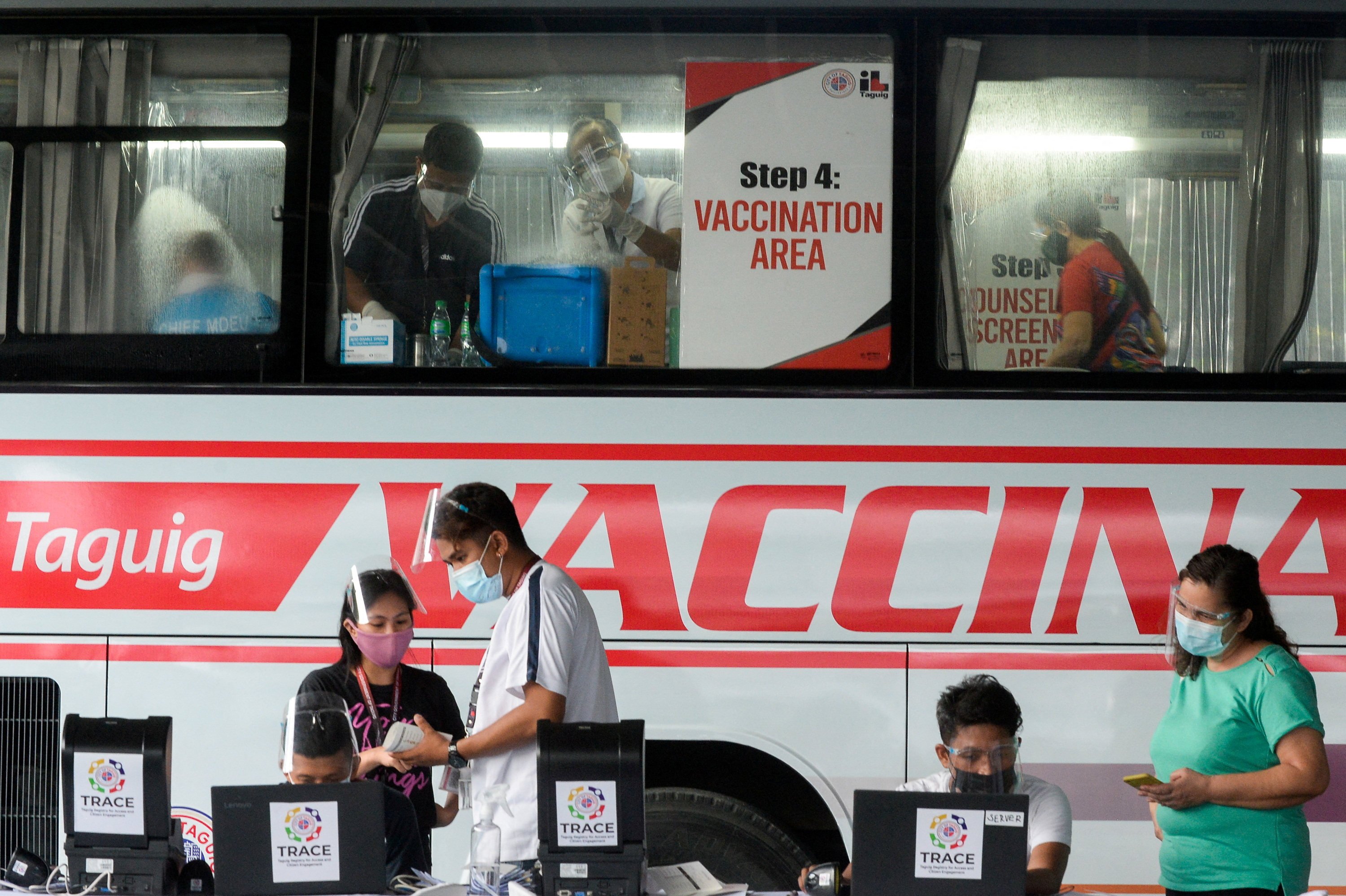 Health workers encode information and prepare vaccines against Covid-19 at a mobile vaccination site in Taguig, Philippines on May 21, 2021. Photo: Reuters