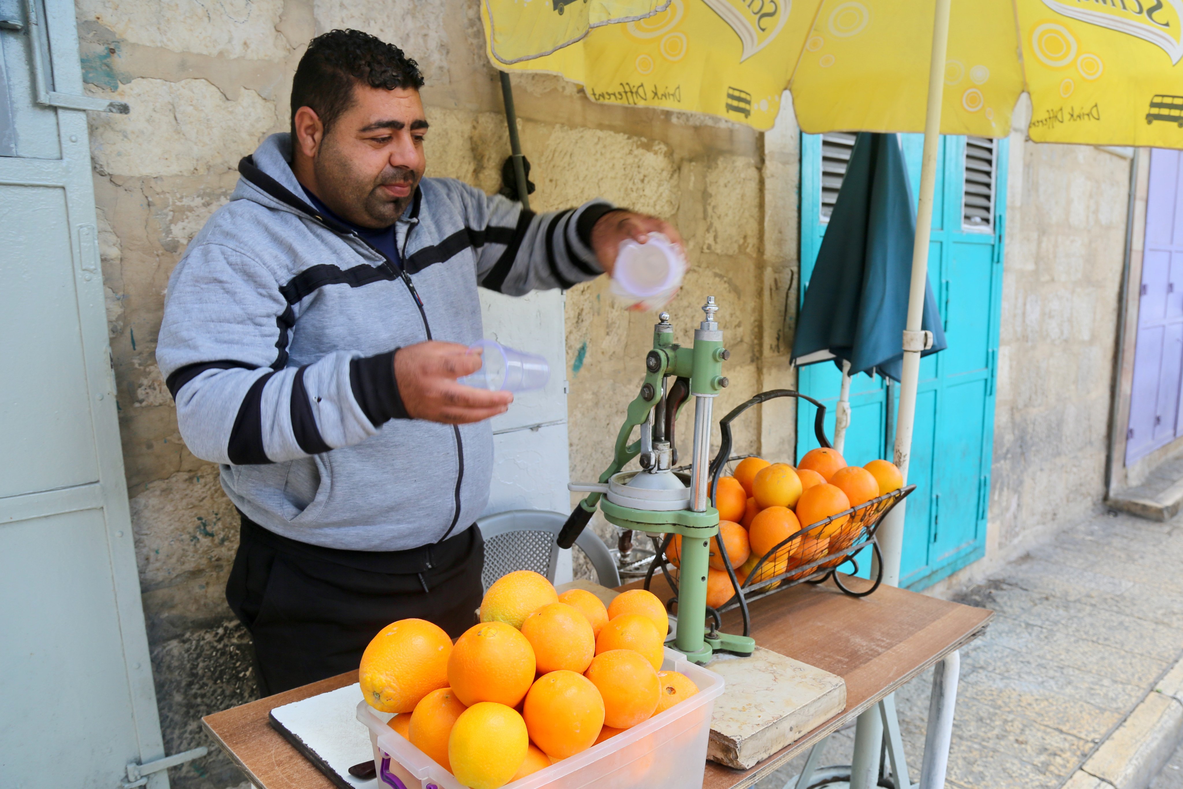 A man sells orange juice in Bethlehem on May 31. Global orange juice prices – already close to double from a year ago – are rising ever higher. Photo: Ian Neubauer