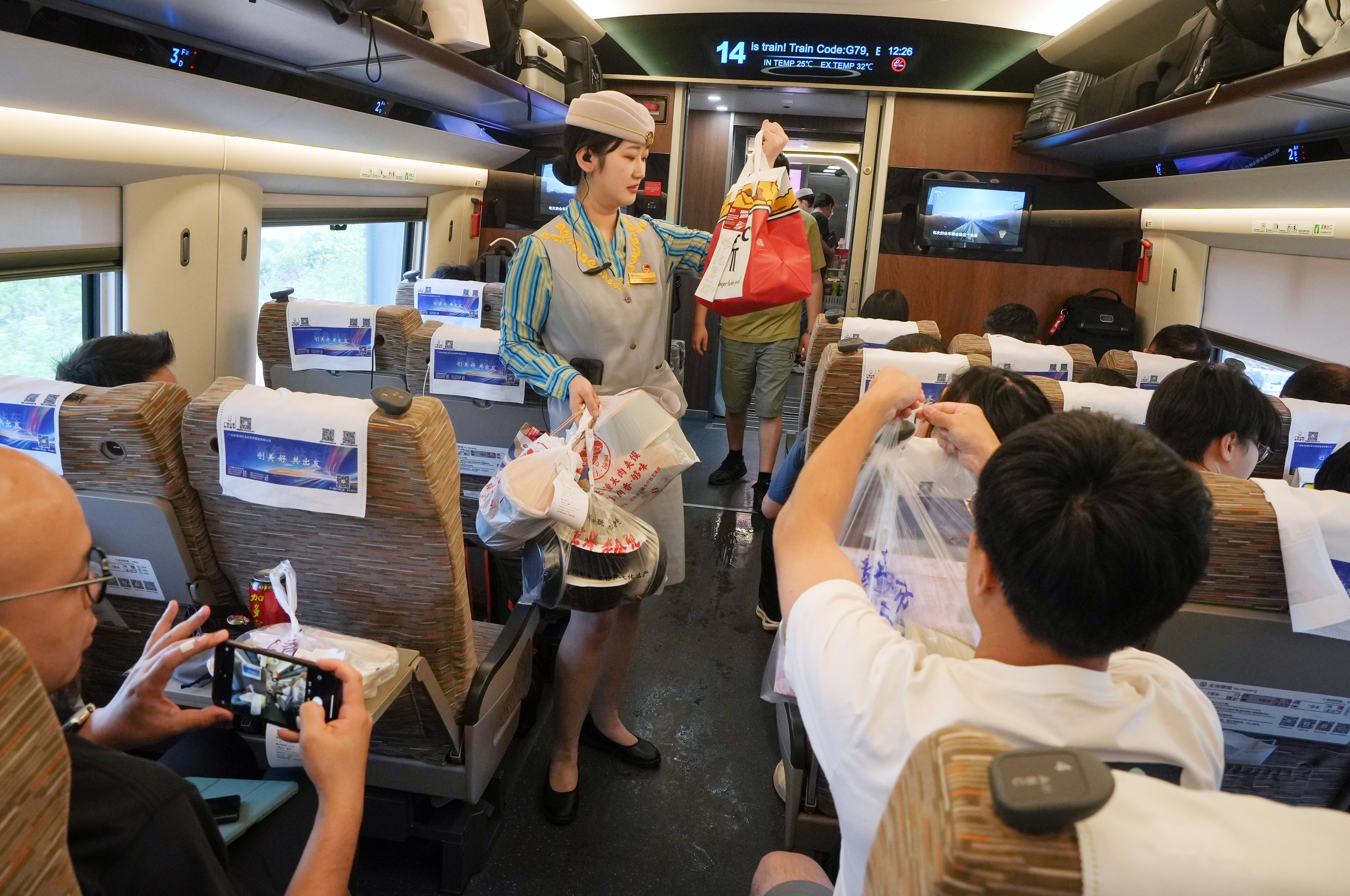 Train crew on an all-seater high-speed train help hand out food deliveries to passengers. Photo: Elson Li