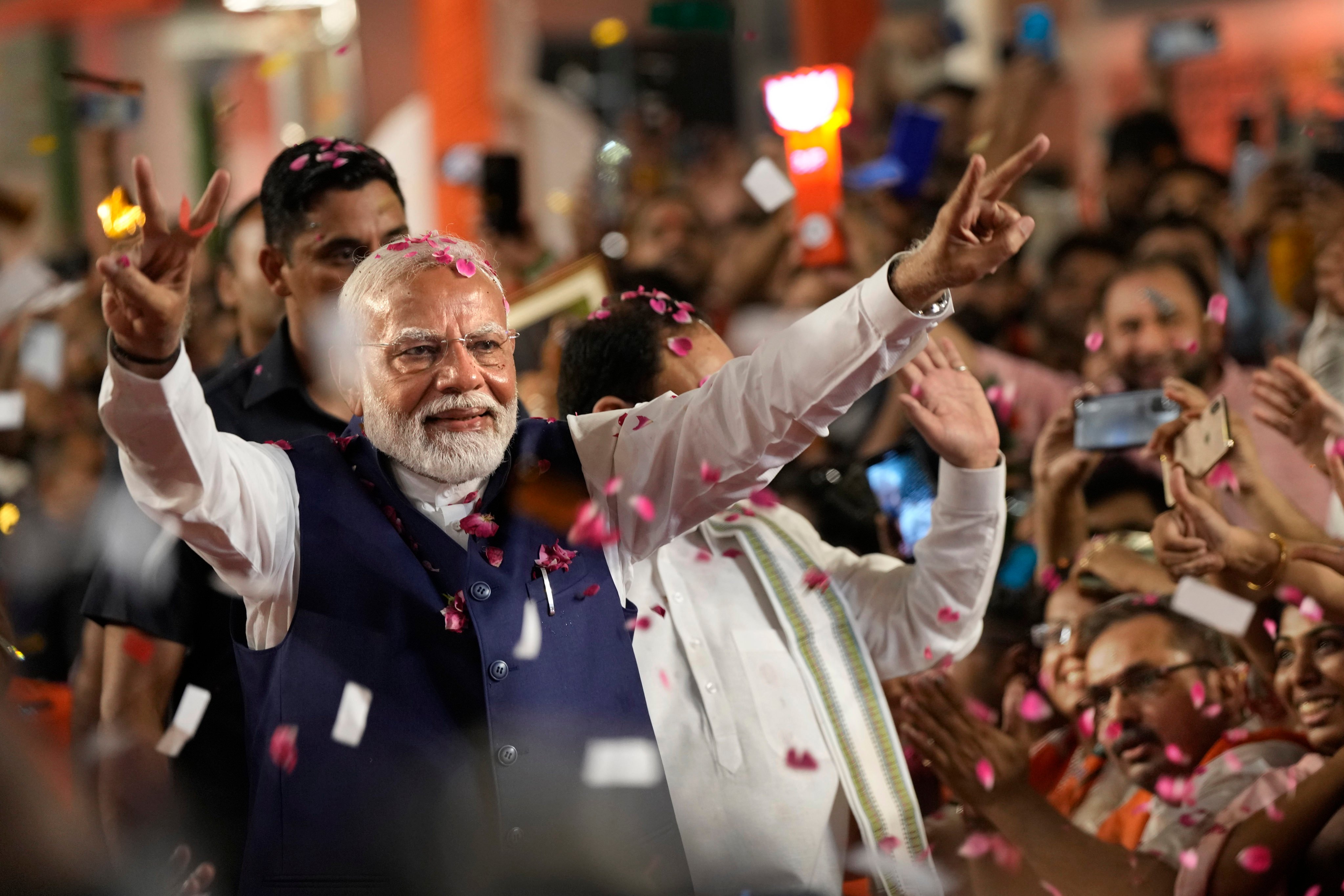 Indian Prime Minister Narendra Modi greets supporters as he arrives at Bharatiya Janata Party headquarters. Photo: AP