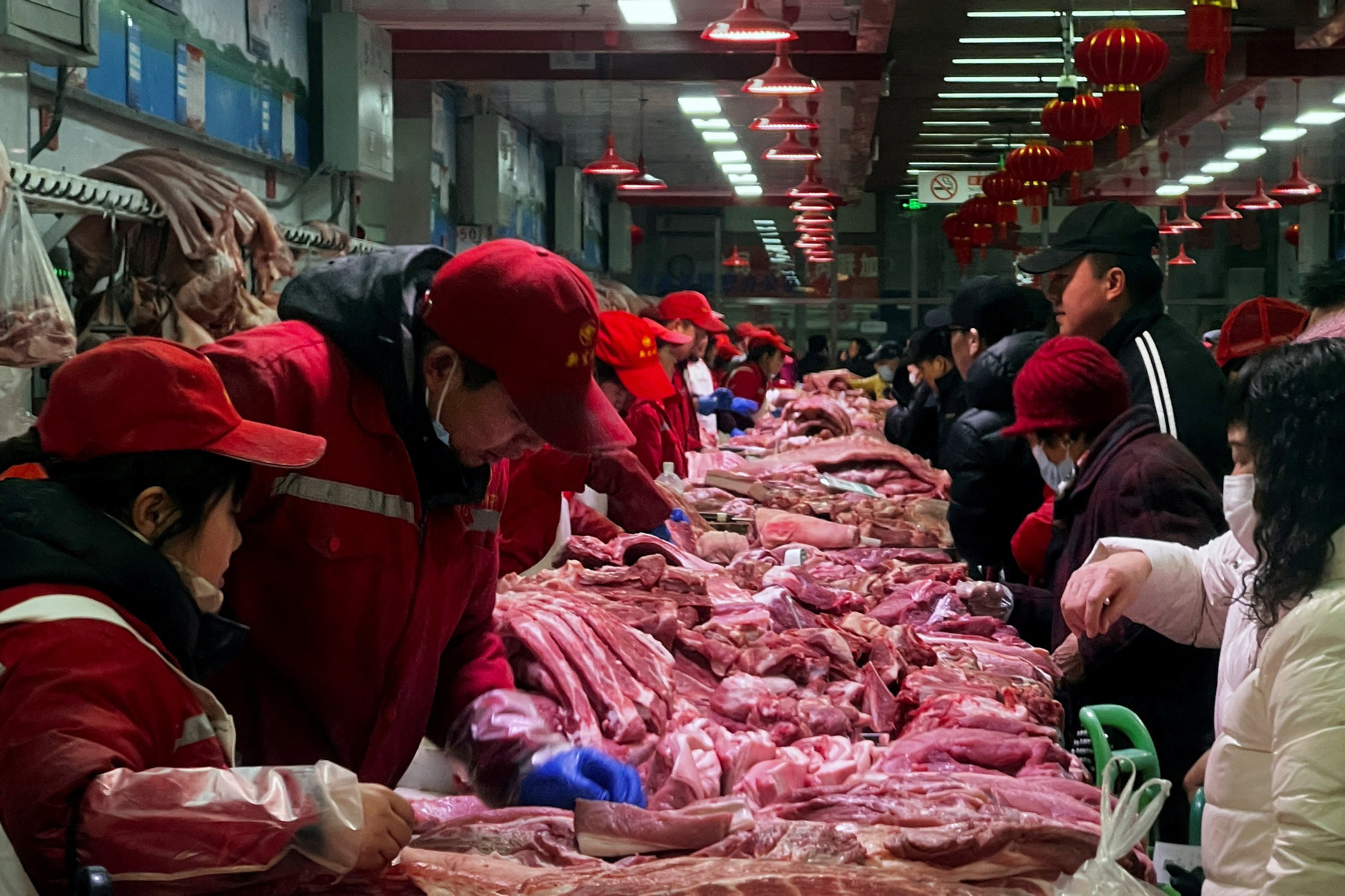 Chinese pork sellers attend to customers at a wholesale market in Beijing. Photo: Reuters