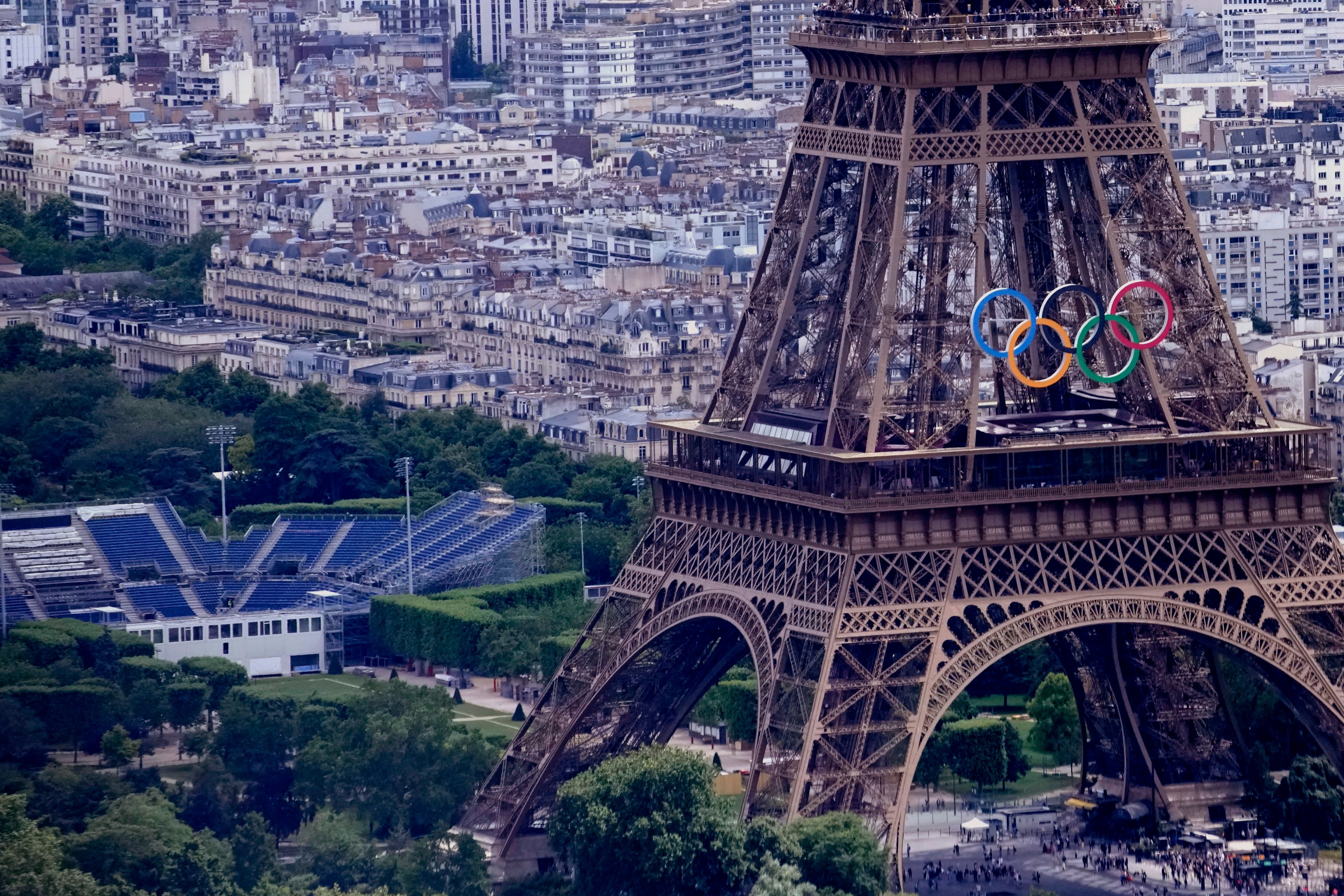 The Olympic rings are seen on the Eiffel Tower in Paris. The Champ-de-Mars on the left will host the beach volleyball. Photo: AP