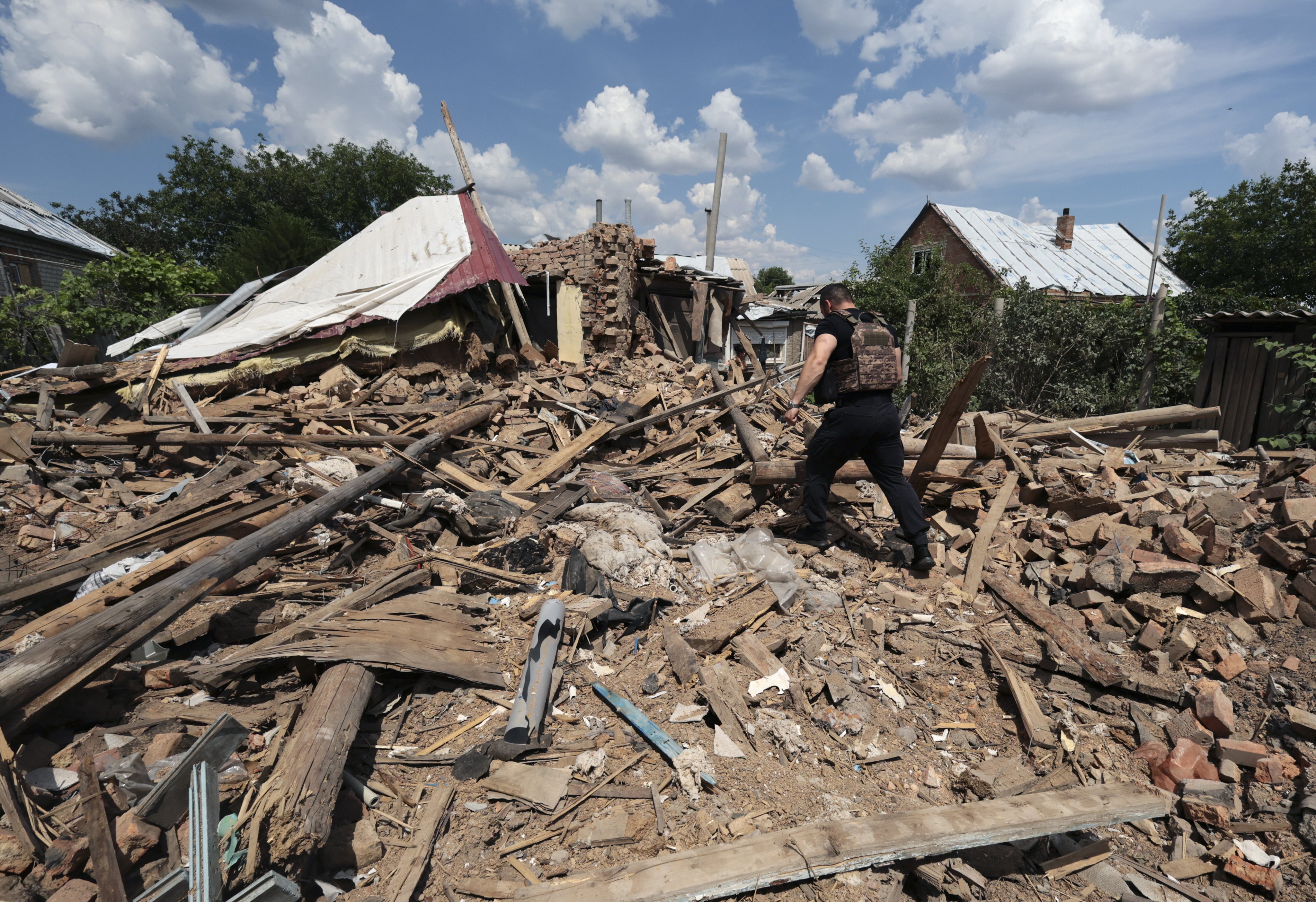 A police officer inspects the rubble of a building hit by Russian shelling in Orikhiv, near the front line in the Zaporizhzhia region of southeastern Ukraine, on June 10. Intense fighting has left parts of Ukraine in dire need of reconstruction, but any large-scale rebuilding likely will have to wait until the conflict ceases. Photo: EPA-EFE