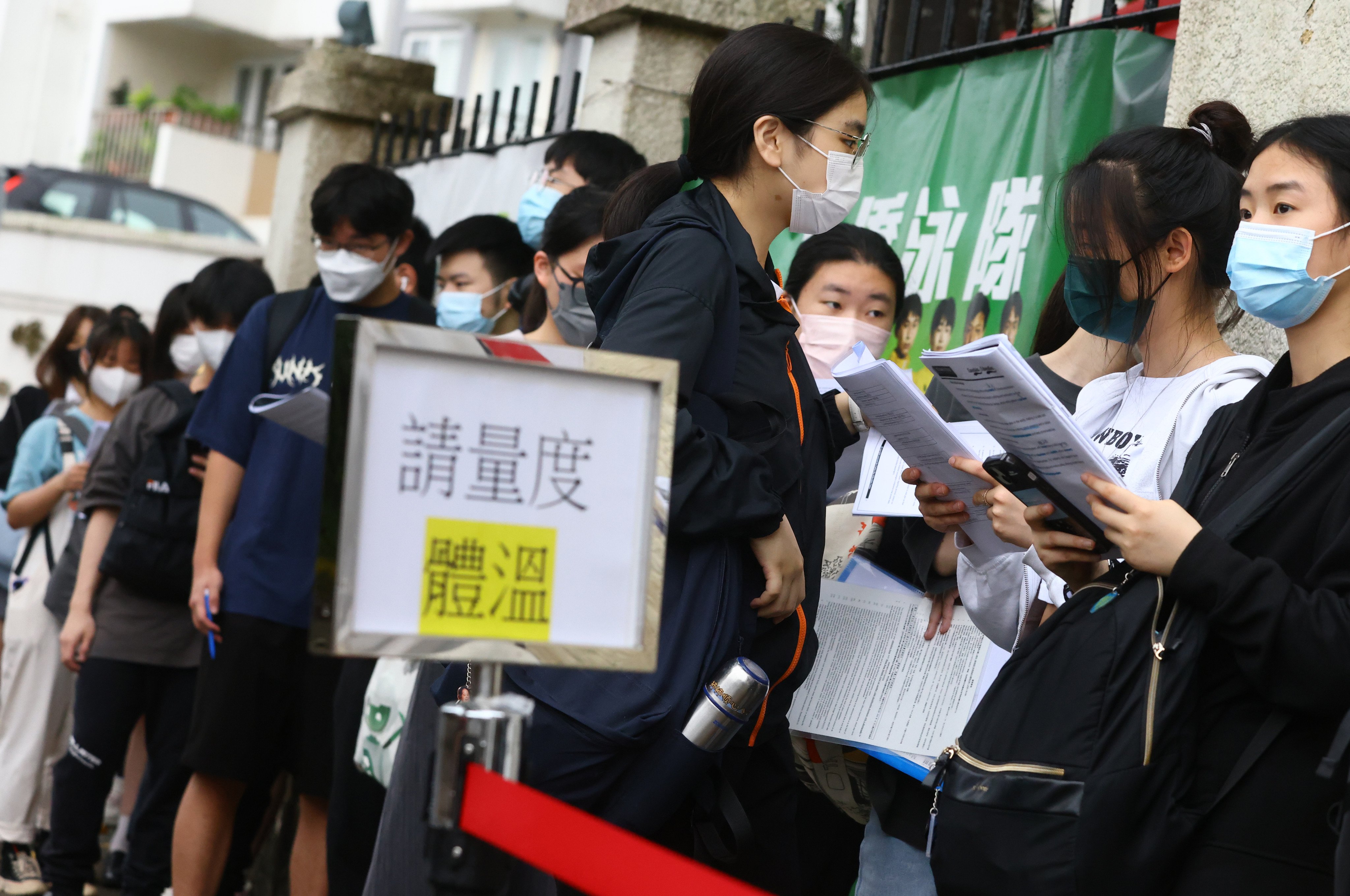 A sign reads in Chinese “Please take your temperature” as students wait to take the DSE English exam at a school in North Point in 2023. Photo: Dickson Lee