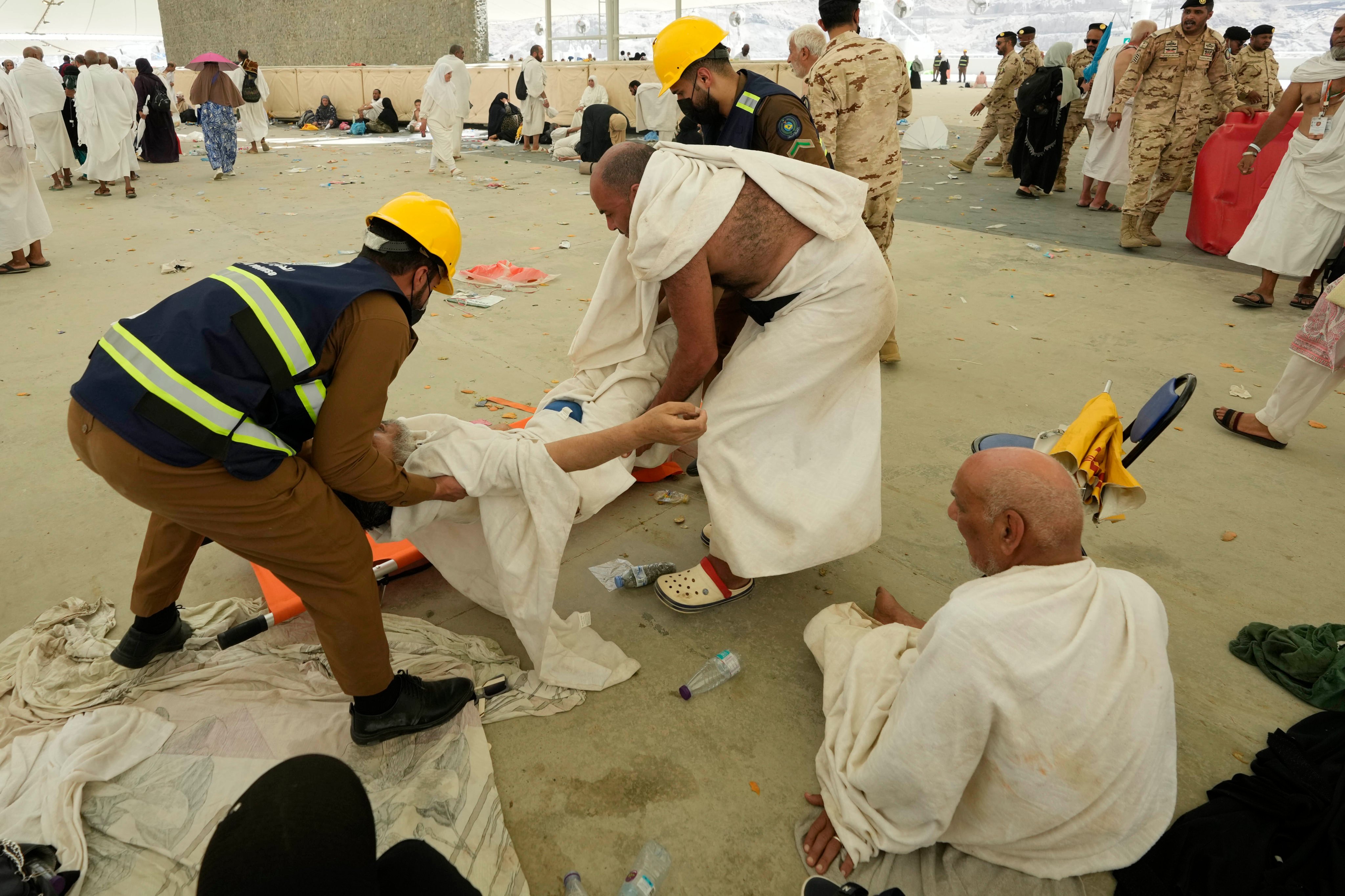 Paramedics carry a muslim pilgrim for a medical check after he fell down due to a heat stroke near Mecca, Saudi Arabia. Photo: AP