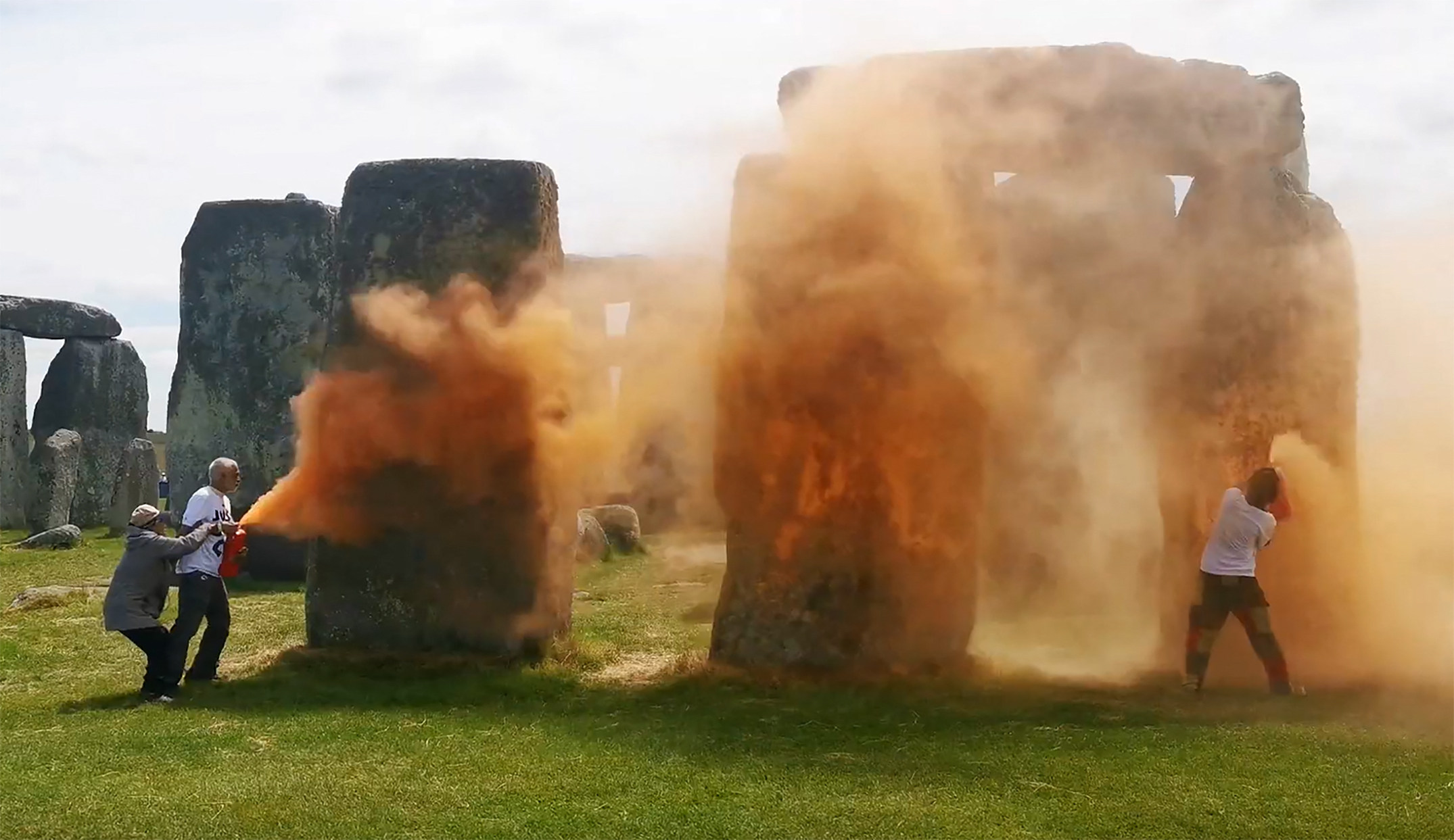 Activists spraying an orange substance at Stonehenge in Wiltshire, England, on Wednesday. Photo: Just Stop Oil via AFP
