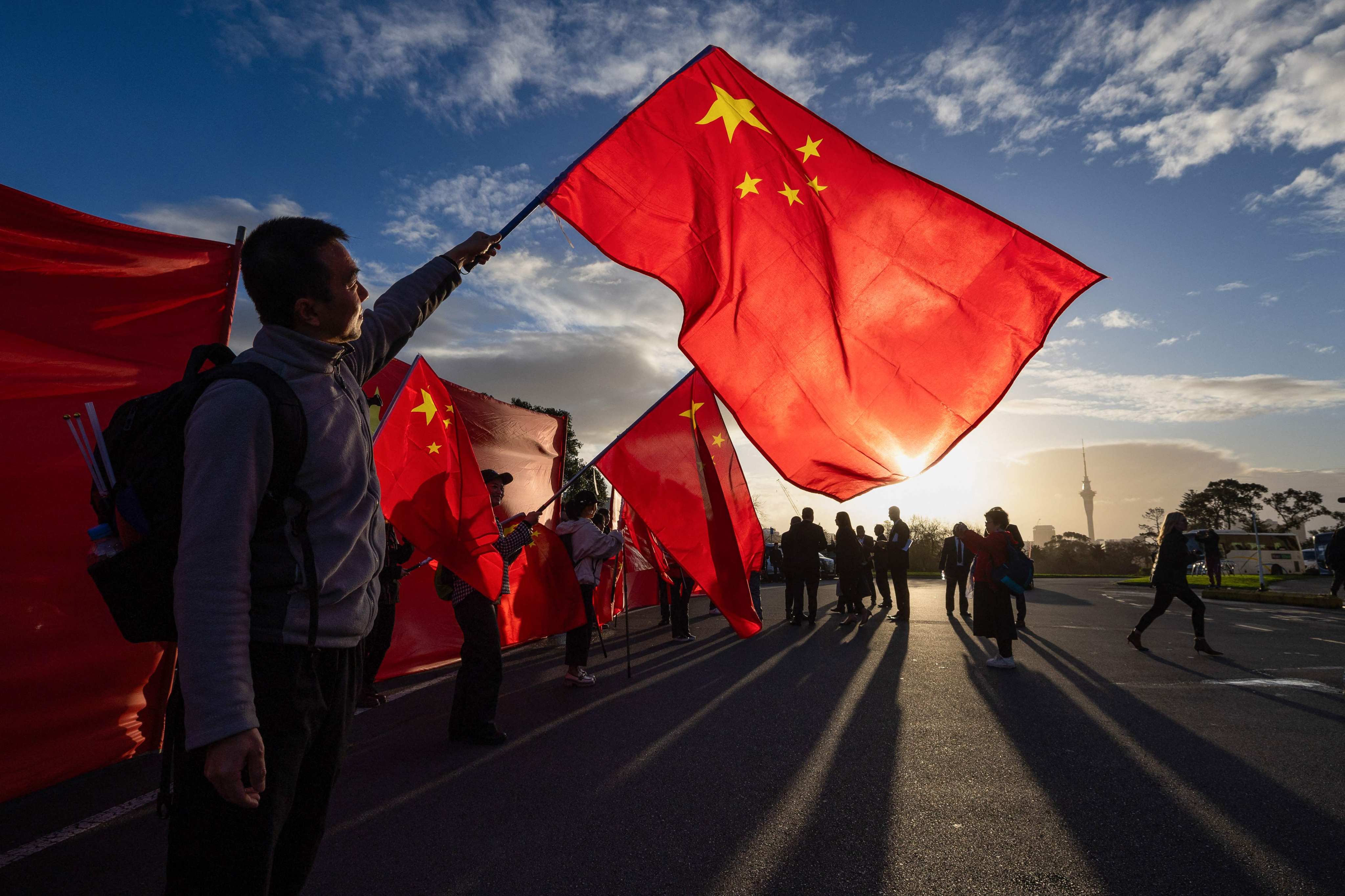Supporters of China’s Premier Li Qiang wave Chinese national flags outside the Auckland Museum in New Zealand on June 14. Photo: AFP