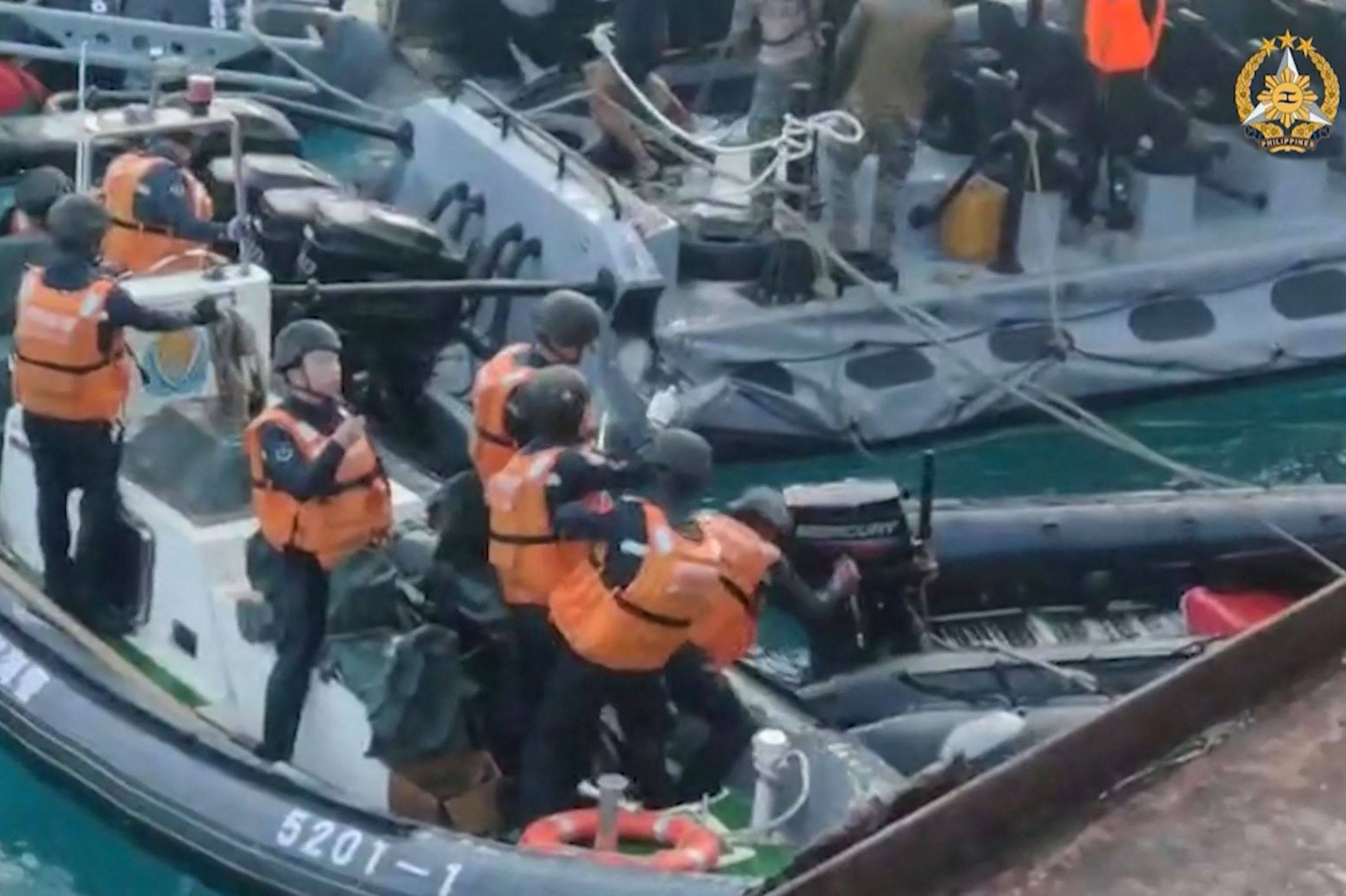 A video frame grab shows a Chinese coastguard member (centre) appearing to try to puncture a Philippine inflatable boat with a weapon during an incident off Second Thomas Shoal in the South China Sea on Monday. Photo: AFP