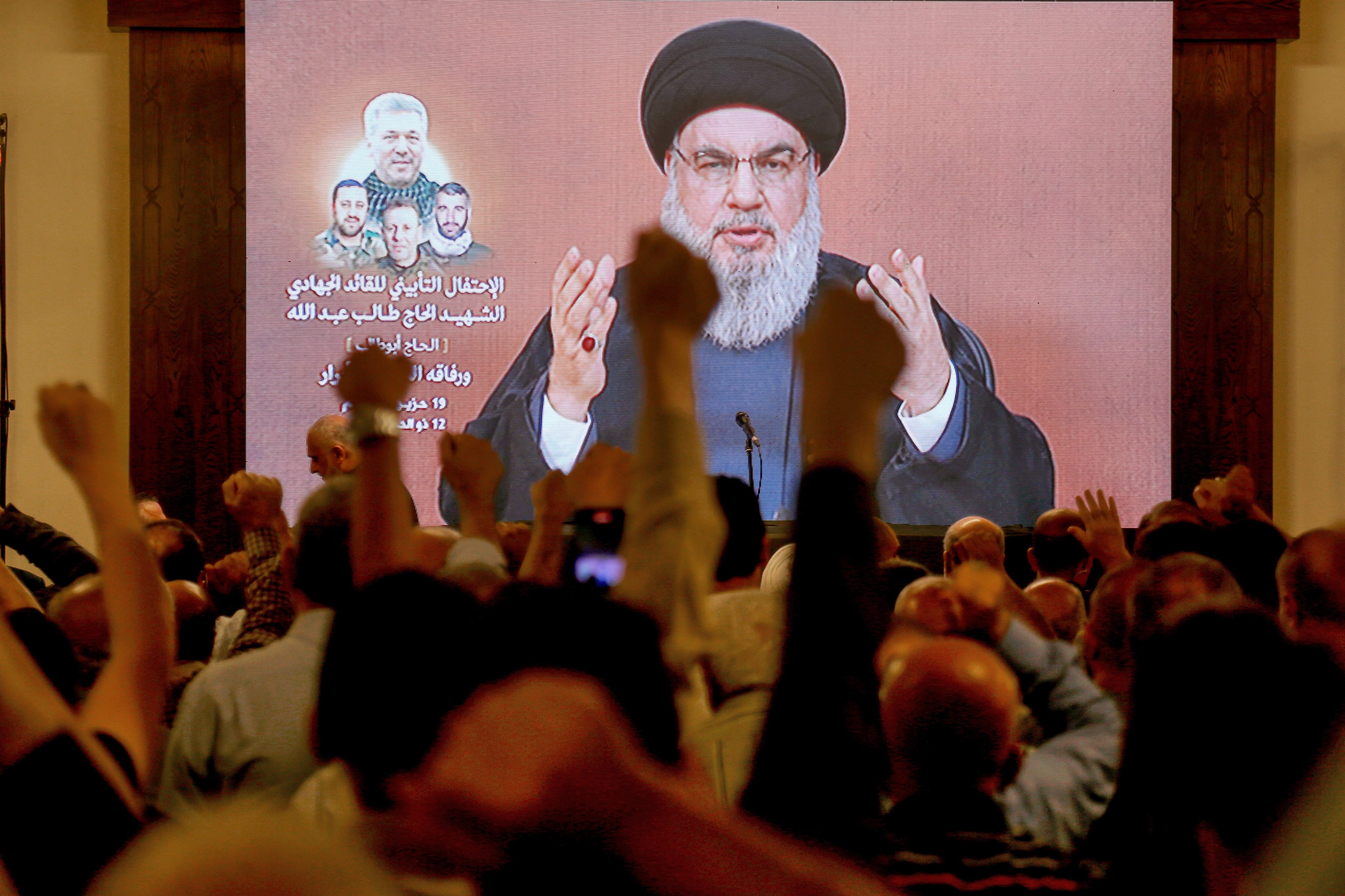 Supporters raise their fists as Lebanon’s Hezbollah leader Hassan Nasrallah gives a televised address on Wednesday. Photo: dpa