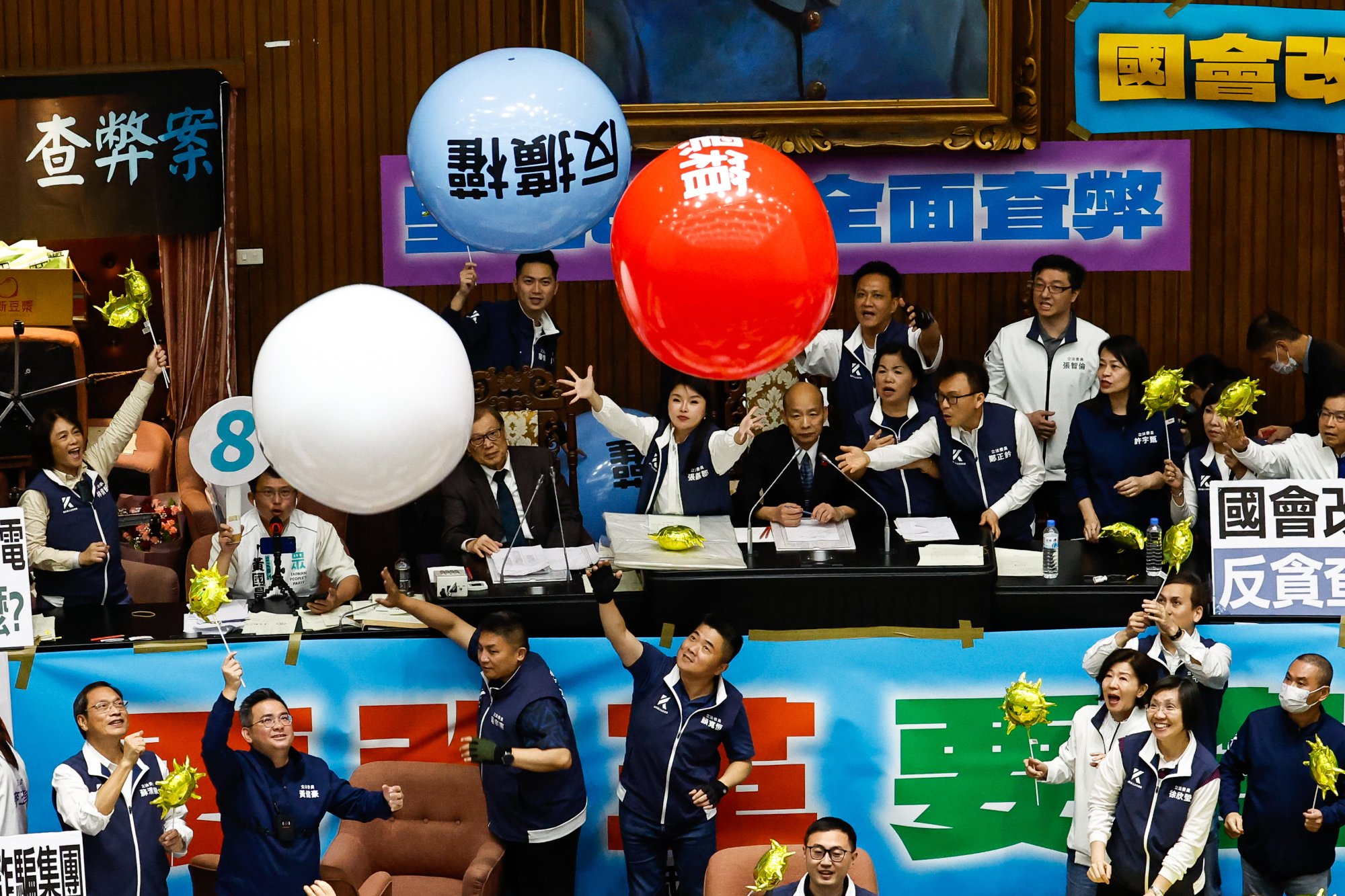 Lawmakers from Taiwan’s ruling Democratic Progressive Party throw balloons protesting the “evil laws” inside the Legislative Yuan on 28 May, as the opposition’s parliamentary reform bills had their third reading. Photo: EPA